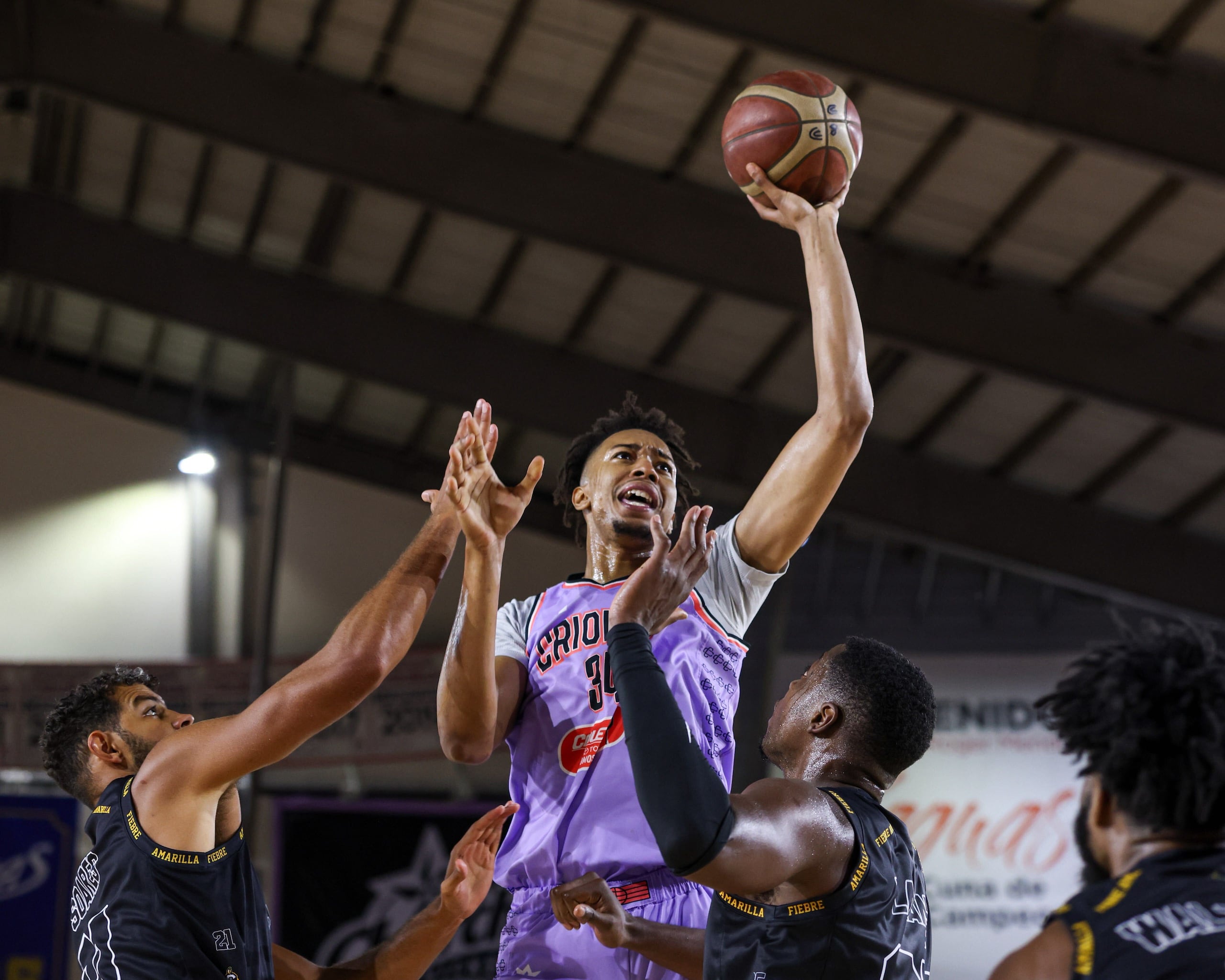 Moses Brown, de los Criollos de Caguas, busca lanzar el balón ante la defensa de los Capitanes de Arecibo.