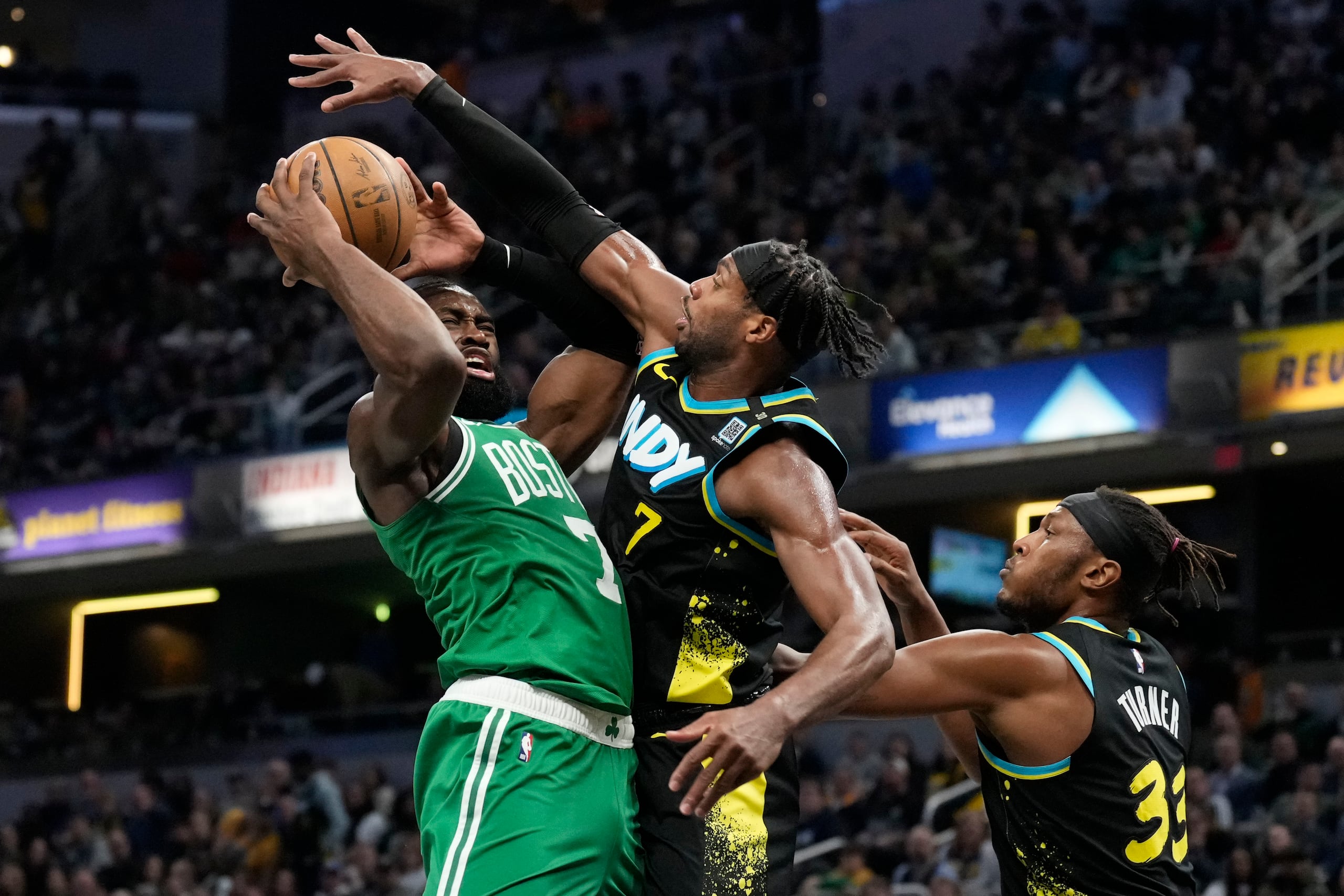 Jaylen Brown, escolta de los Celtics de Boston, ataca el canasto frente a Buddy Hield, alero de los Pacers de Indiana.