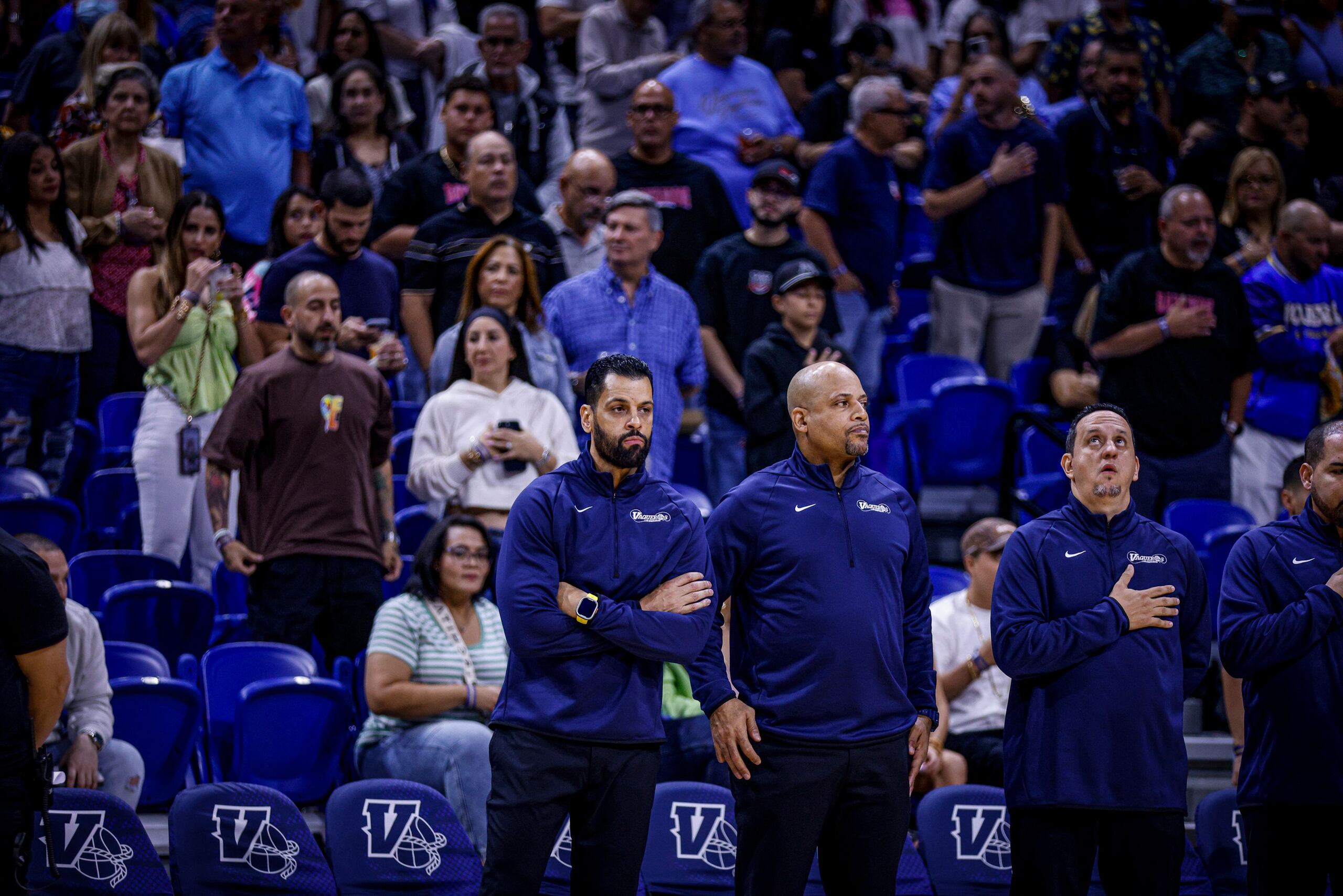 Christian Dalmau (izquierda) y Larry Ayuso (centro) previo a su debut en el cuerpo técnico de los Vaqueros de Bayamón. Dalmau dirige al equipo con la asistencia de Ayuso y Jorge Rincón (derecha).