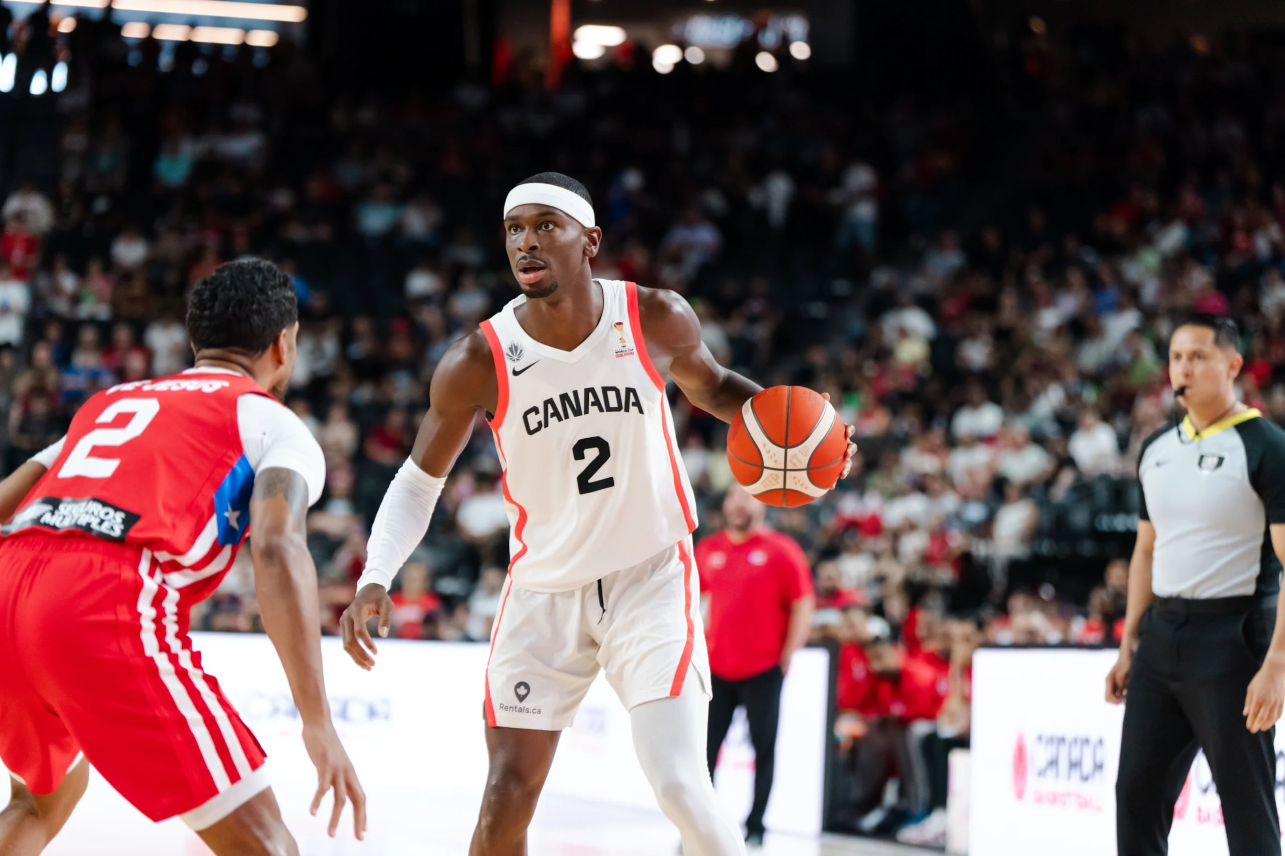 Shai Gilgeous-Alexander, de Canadá, maneja el balón ante la defensa de Jezreel De Jesús, de Puerto Rico.