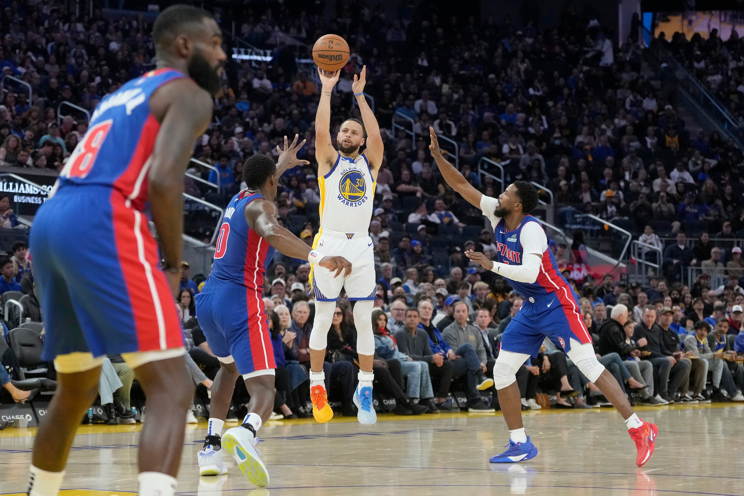 Stephen Curry lanza al canasto ante la defensa de los Pistons de Detroit.