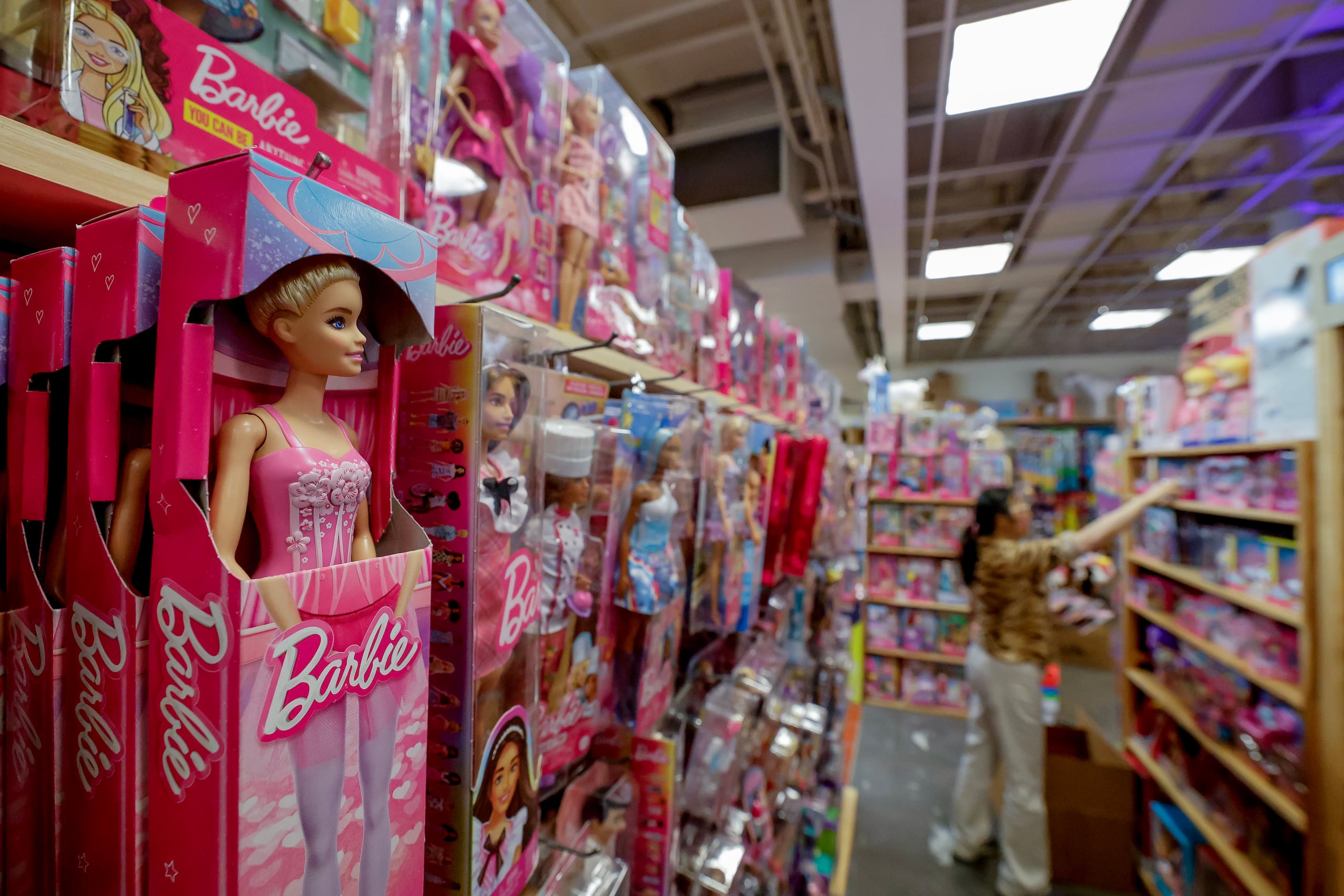 La propietaria de una tienda de juguetes independiente, Ming 'Yaya' Yang, repone su inventario de productos Barbie fabricados por Mattel en Richard's Variety Store antes del aumento de precios previsto debido a los aranceles esperados, en Atlanta, Georgia, EE.UU. EFE/EPA/ERIK S. LESSER