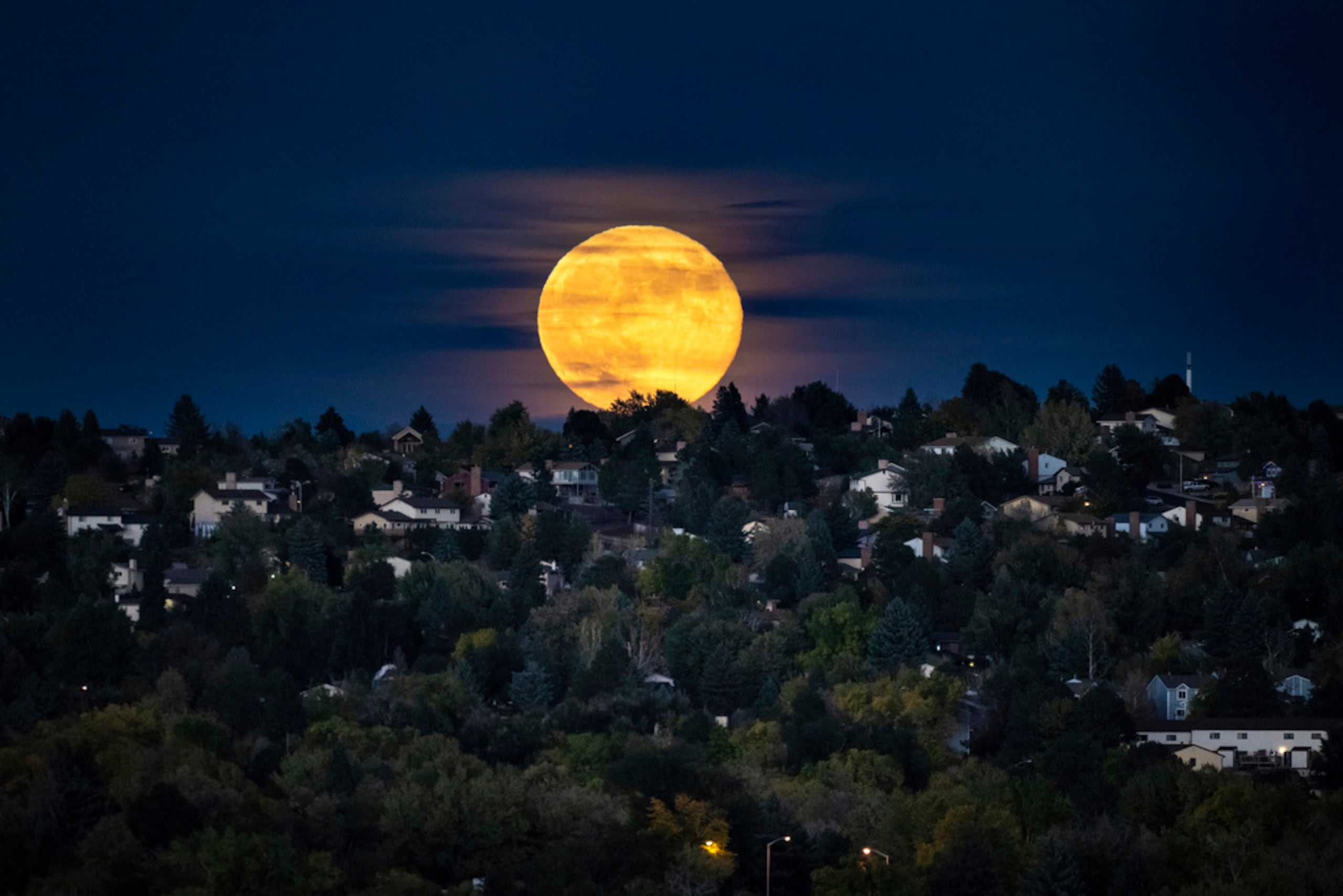 La superluna, la Luna más grande y brillante del año, se eleva sobre un vecindario, el 17 de octubre de 2024, en Colorado Springs, Colorado.