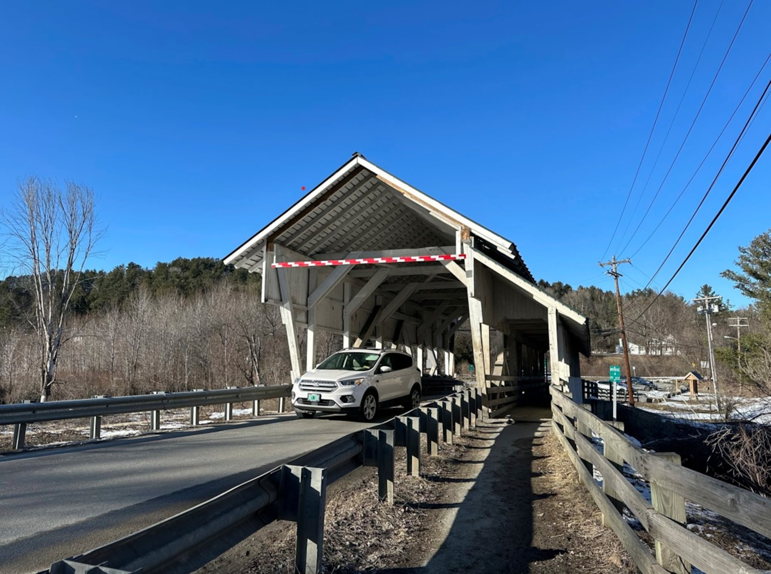 Un vehículo pasa por el puente cubierto Miller's Run en Lyndon, Vermont.