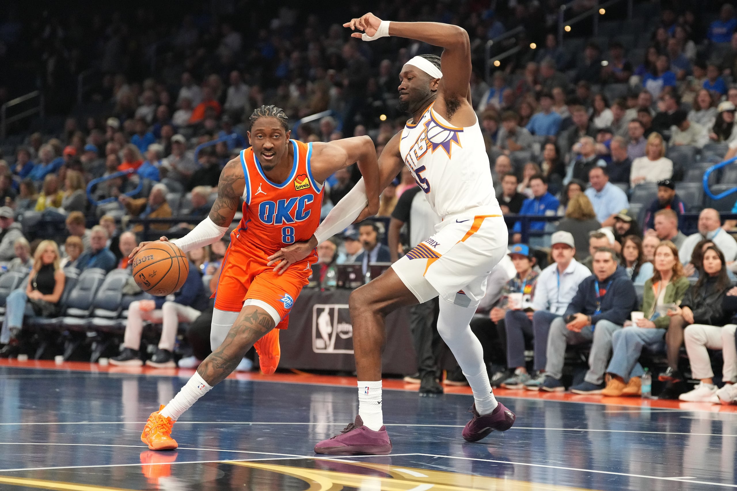Jalen Williams, izquierda, del Thunder de Oklahoma City, lleva el balón rumbo a la canasta dejando en el camino a Mark Williams, derecha, de los Suns de Phoenix, durante la segunda mitad del partido de baloncesto de la Copa NBA, el miércoles 10 de diciembre de 2025, en Oklahoma City. (AP Foto/Kyle Phillips)