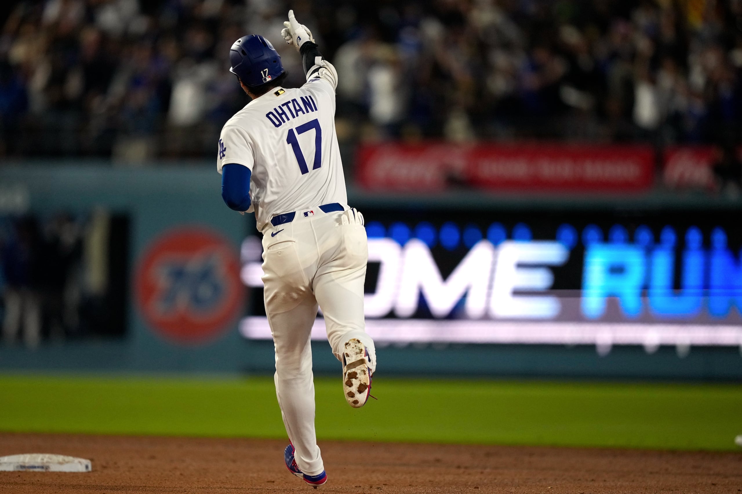 Shohei Ohtani, de los Dodgers de Los Ángeles, hace un gesto mientras dobla por la segunda base tras conectar un jonrón solitario.