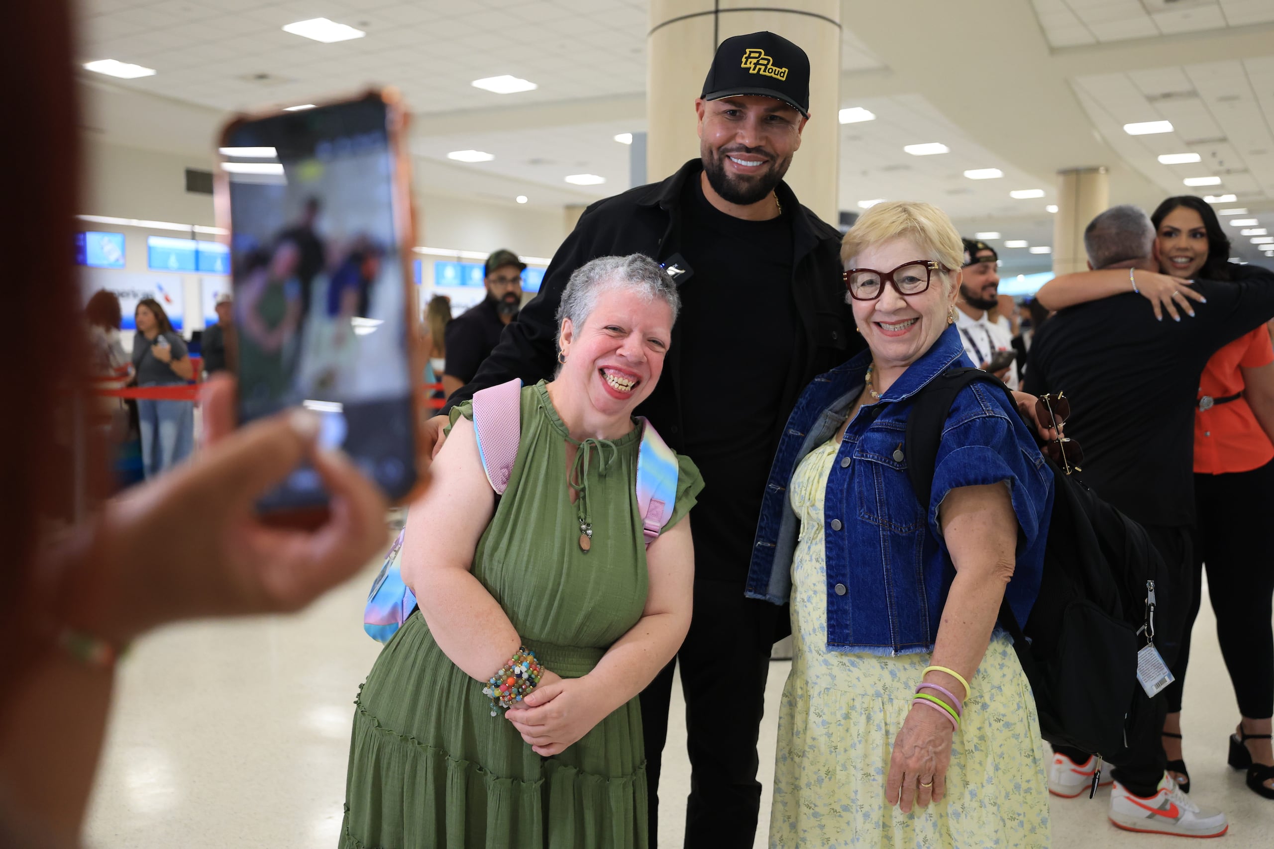 Carlos Beltrán antiende a unas fanáticas en el Aeropuerto Luis Muñoz Marín antes de partir a Cooperstown, Nueva York.