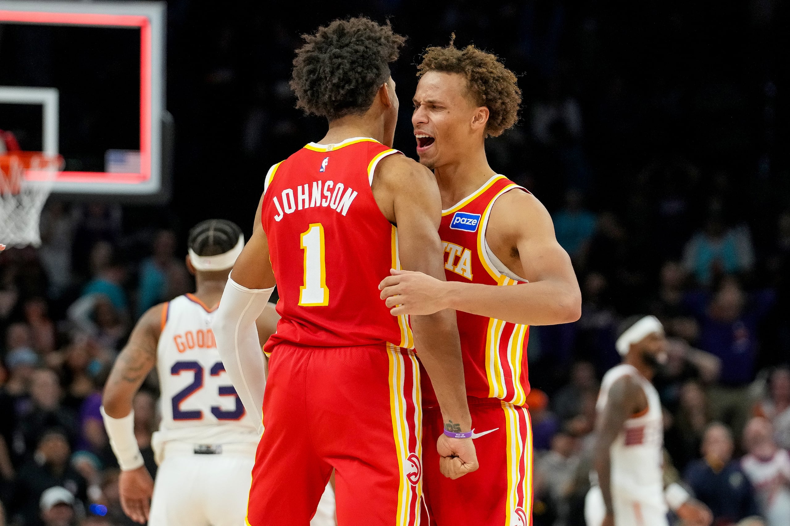 Jalen Johnson (1) y Dyson Daniels, de los Hawks de Atlanta, celebran una remontada ante los Suns de Phoenix durante la segunda mitad del juego de baloncesto de la NBA, el domingo 16 de noviembre de 2025. Atlanta ganó 124-122. (AP Foto/Darryl Webb)