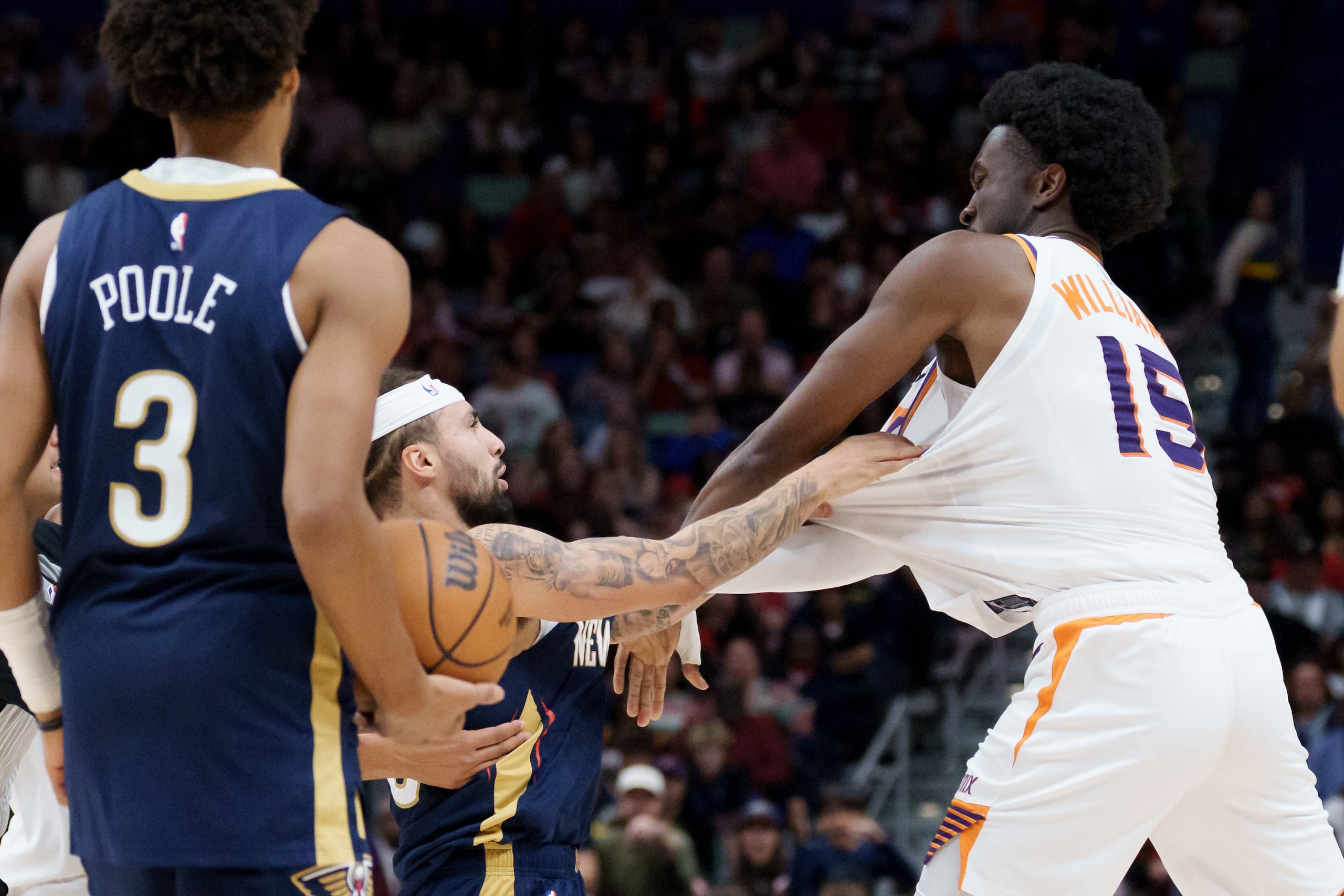 José Alvarado, izquierda, de los Pelicans de Nueva Orleans, y Mark Williams (15), de los Suns de Phoenix, se trenzan en un intercambio de golpes durante el tercer cuarto un partido de baloncesto de la NBA antes de ser expulsados el sábado 27 de diciembre de 2025, en Nueva Orleans. (AP Foto/Matthew Hinton)