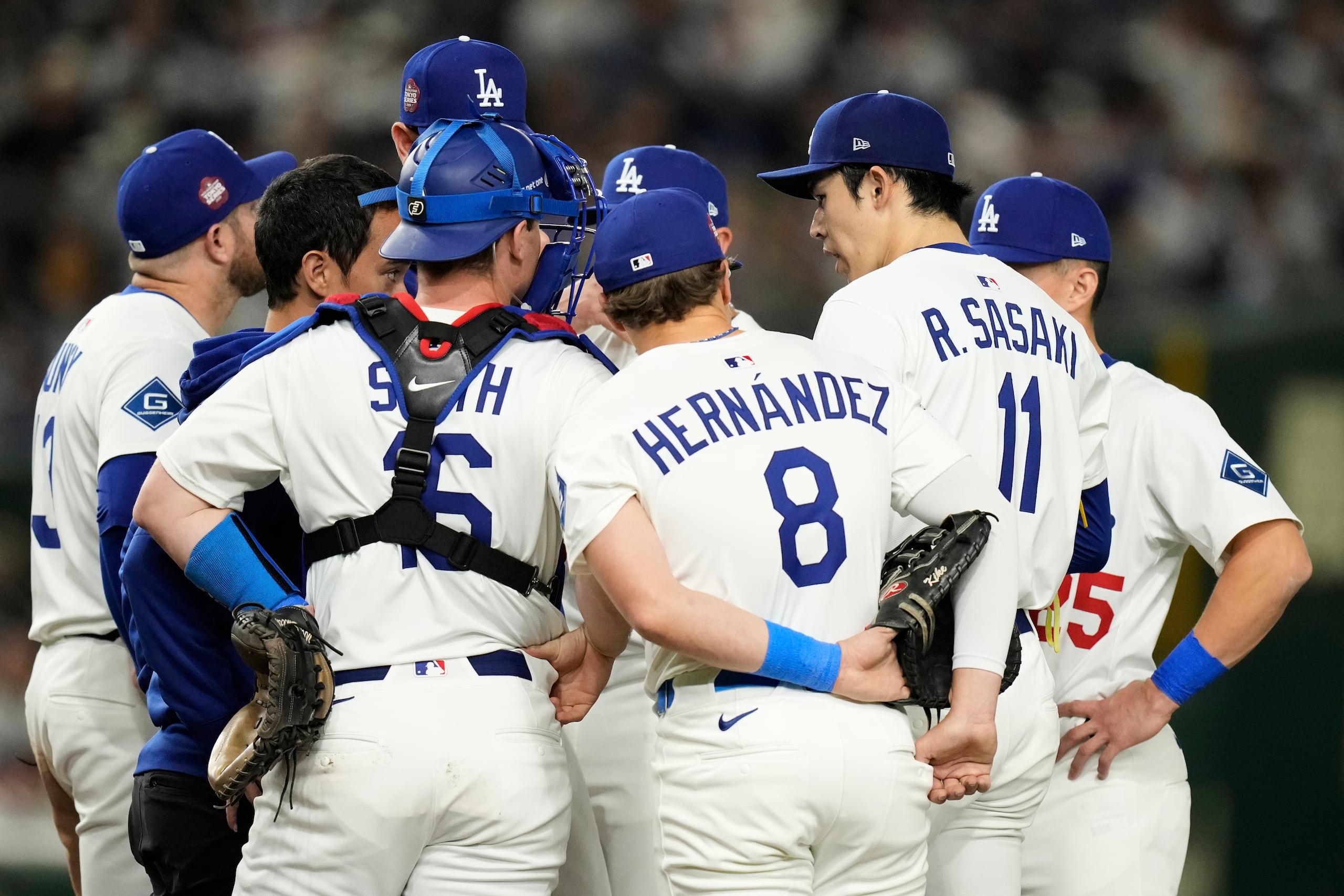 Los jugadores de los Dodgers se reúnen alrededor del lanzador japonés Roki Sasaki durante una visita en la tercera entrada. El lanzador realizaba su primera apertura en un juego de las Grandes Ligas.