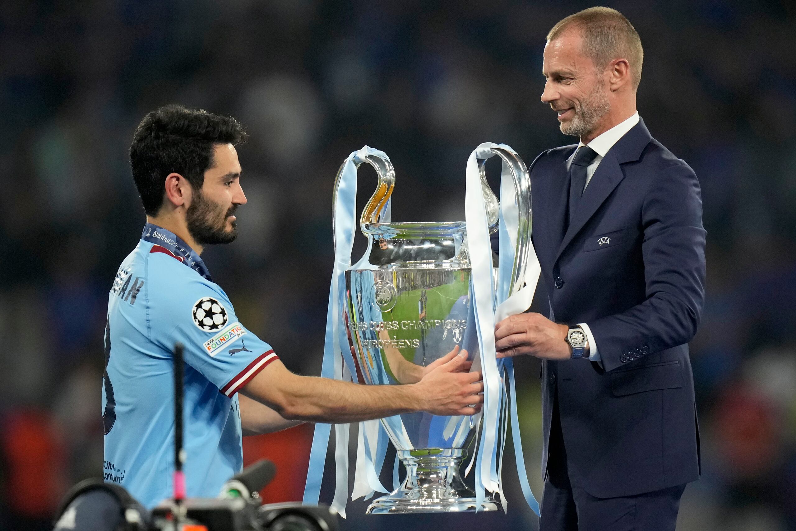 El presidente de la UEFA Aleksander Ceferin entrega el trofeo de la Liga de Campeones al capitán del Manchester City Ilkay Gundogan, luego de la victoria ante el Inter de Milán.