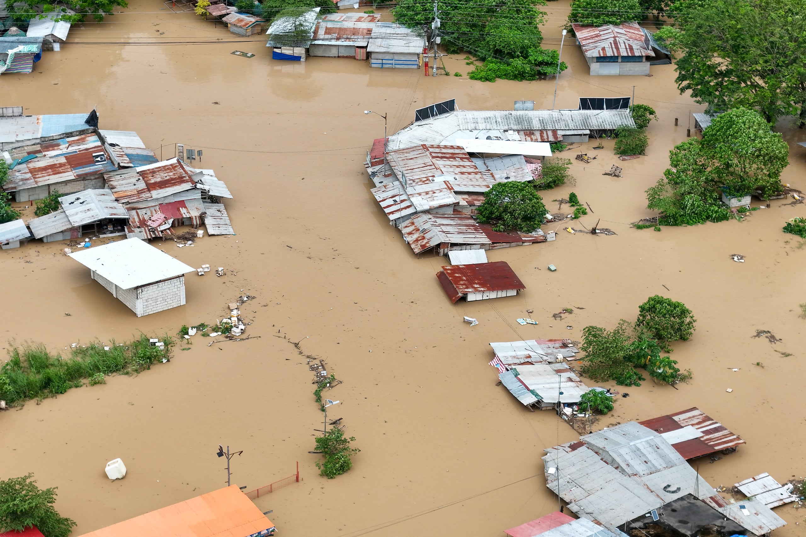 This photo shows an aerial view of flooded houses in Tuguegarao City, Cagayan province, north of Manila on November 10, 2025, after a river overflowed following heavy rains brought about by Super Typhoon Fung-wong. A weakening Typhoon Fung-wong departed the Philippines over the South China Sea on the morning of November 10, after its driving winds and heavy rain killed at least two people and forced more than a million to evacuate. (Photo by John DIMAIN / AFP)
