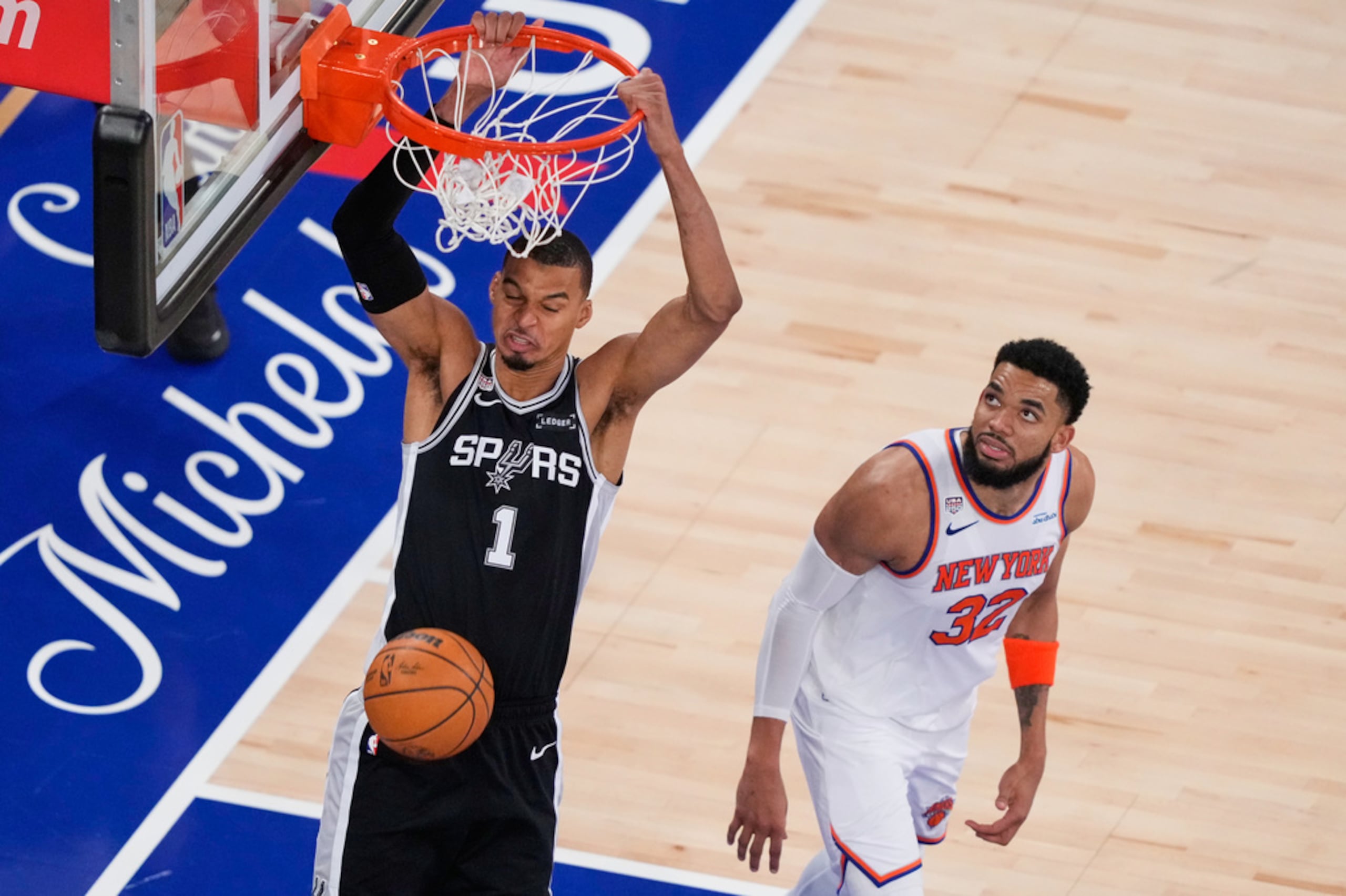 Victor Wembanyama (1), de los Spurs de San Antonio, clava el balón mientras Karl-Anthony Towns (32), de los Knicks de Nueva York, observa durante la segunda mitad del tercer juego de las Finales de la NBA, el 8 de junio de 2026, en Nueva York.