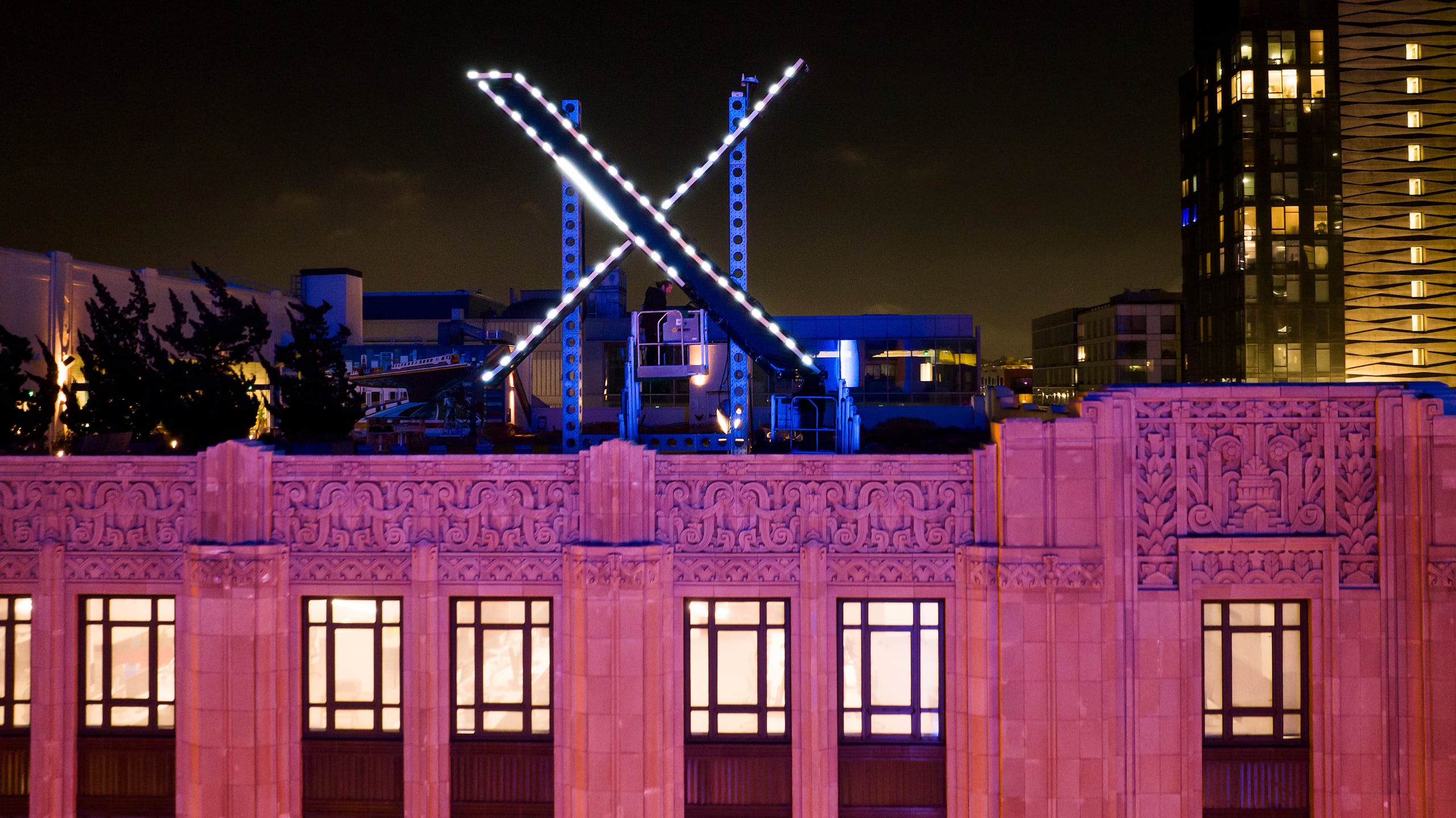 Trabajadores instalan una "X" luminosa en el techo de la empresa, antes llamada Twitter, en el centro de San Francisco, 28 de julio de 2023.  Se ha retirado el cartel días después de su instalación. (AP Foto/Noah Berger)