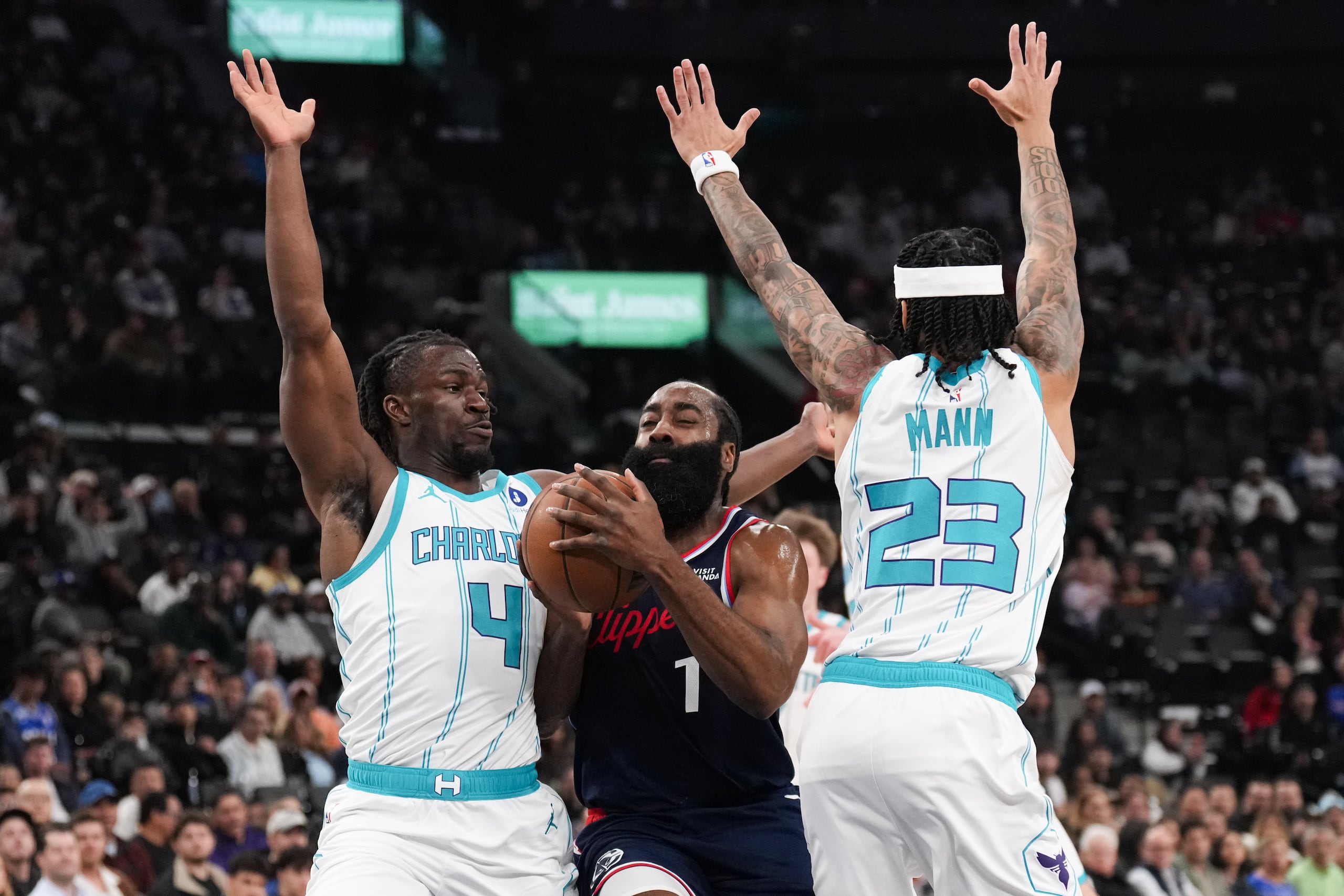 James Harden (1), de los Clippers de Los Ángeles, es defendido por Sion James (4) y Tre Mann (23), de los Hornets de Charlotte, durante la primera mitad del juego de baloncesto de la NBA, el lunes 12 de enero de 2026, en Inglewood, California. (AP Foto/Jae C. Hong)