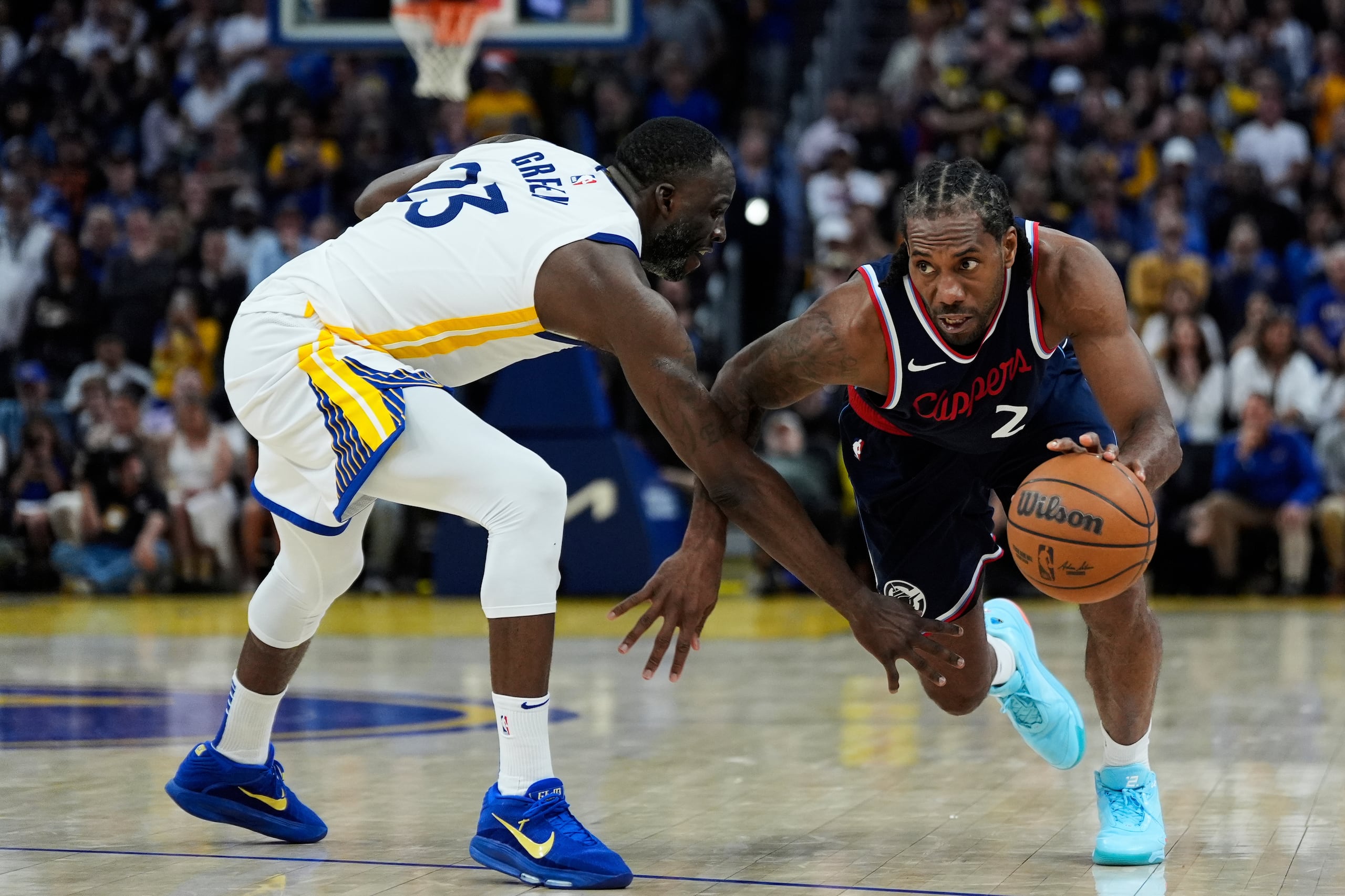 El alero de los Clippers de Los Ángeles, Kawhi Leonard (2), mueve el balón mientras es defendido por el alero de los Warriors de Golden State, Draymond Green (23), durante el tiempo extra de un partido de baloncesto de la NBA.