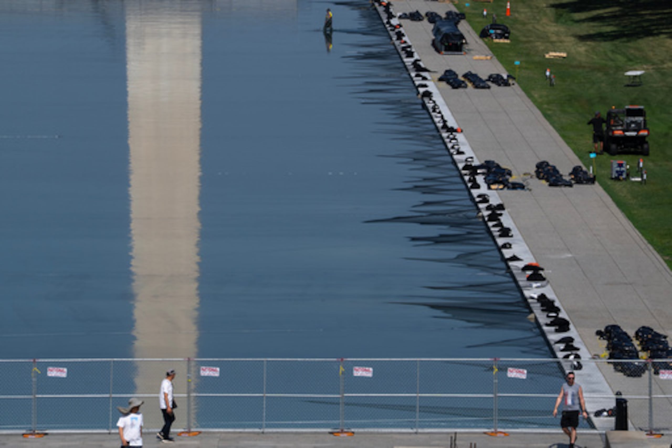 Unos trabajadores instalan fuegos artificiales a lo largo del borde del estanque reflectante del Monumento a Lincoln, con vistas a la celebración del 4 de julio «America 250» en el National Mall, el jueves 2 de julio de 2026, en Washington. (Foto AP/Nathan Howard)