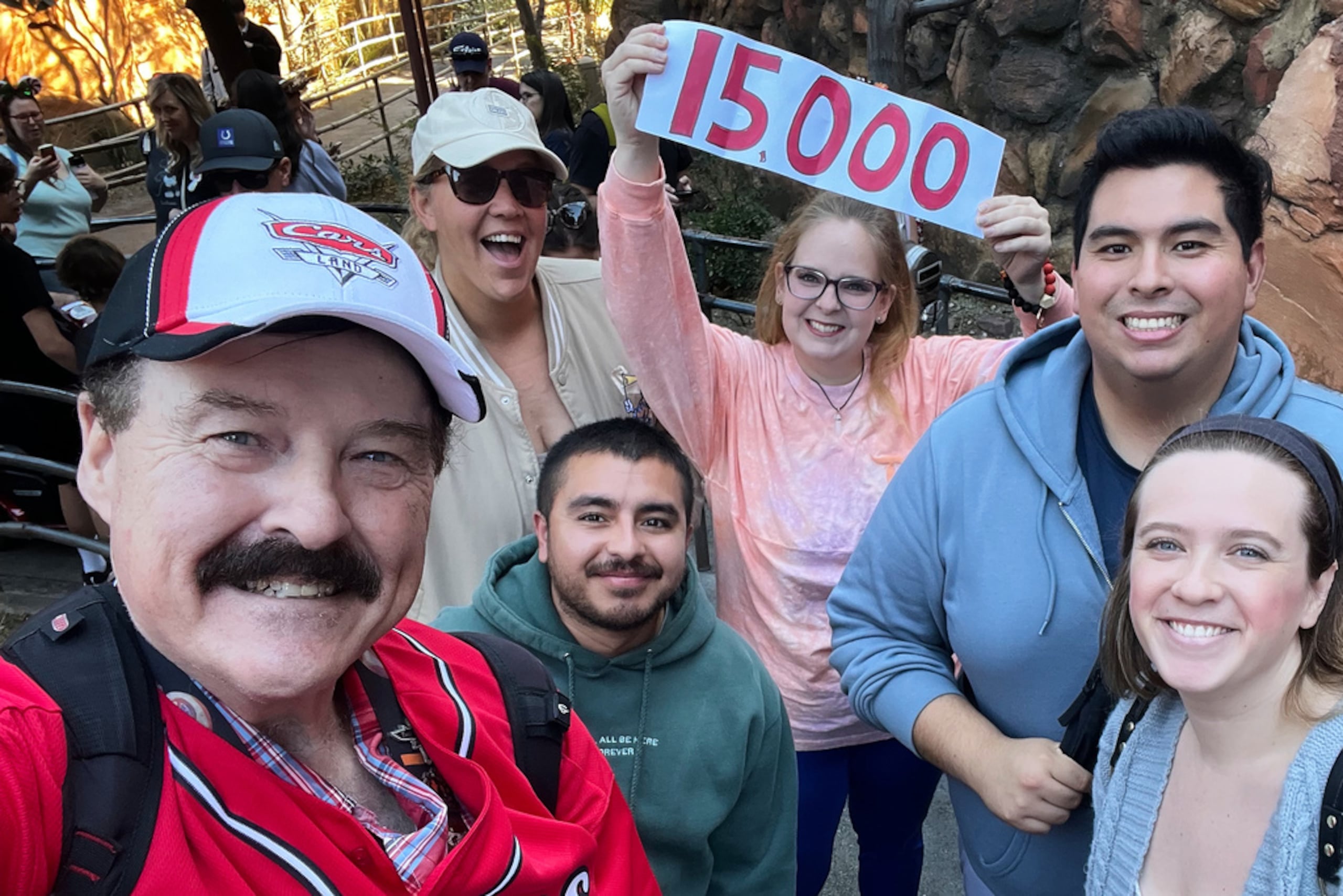 Jon Alan Hale -a la izquierda- posa con amigos después de completar su giro número 15,000 en "Radiator Springs Racers", en Disney California Adventure, California, el 8 de diciembre de 2025.