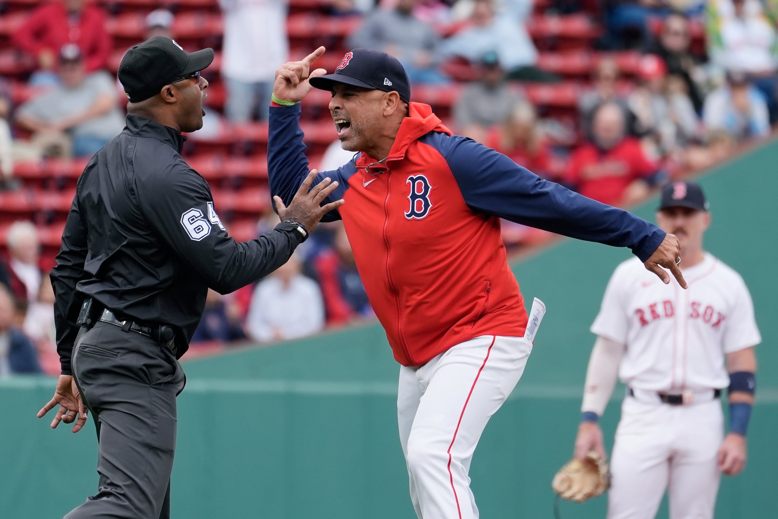 Boston Red Sox manager Alex Cora argues with umpire Alan Porter (64) after being ejected during the first inning of the first game of a baseball doubleheader against the Minnesota Twins, Sunday, Sept. 22, 2024, in Boston. (AP Photo/Michael Dwyer)