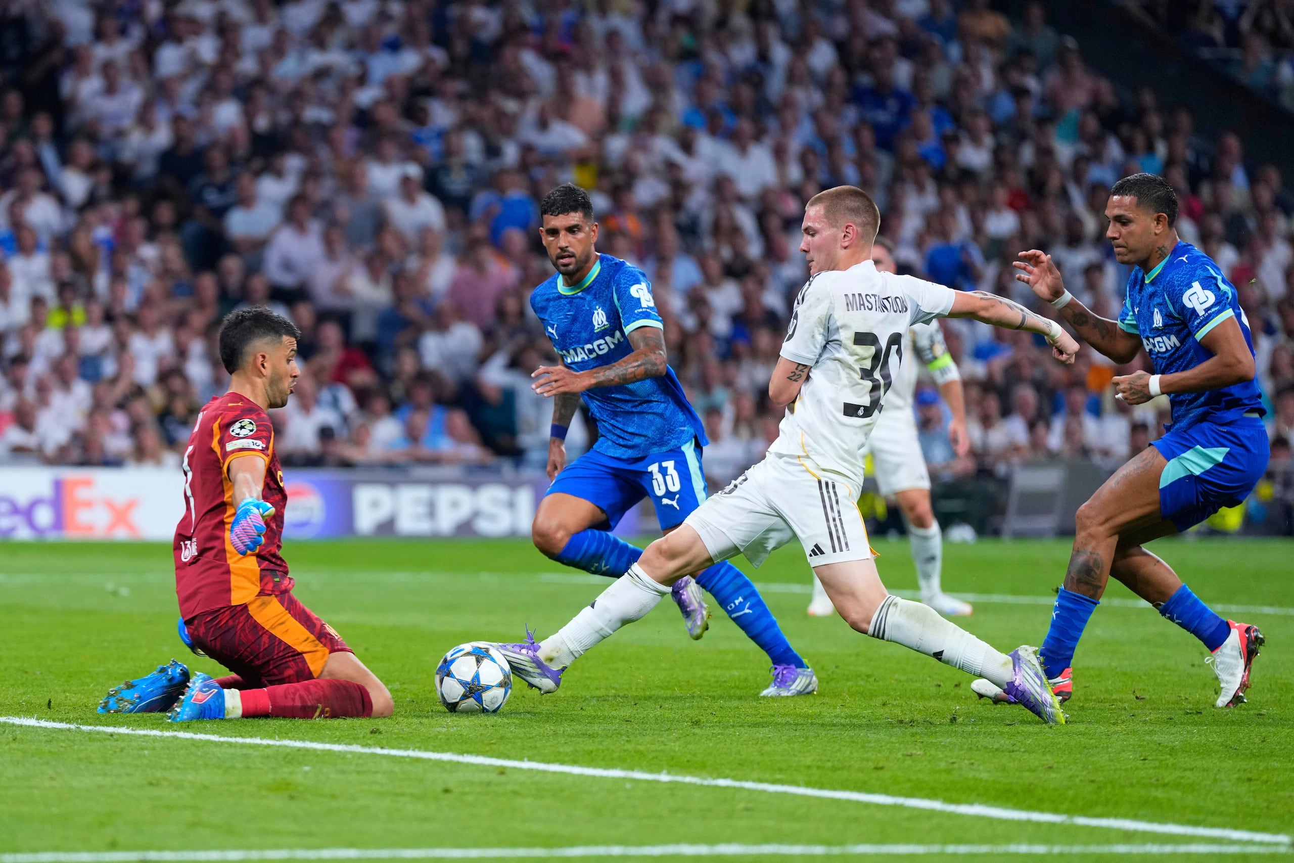 Franco Mastantuono del Real Madrid avanza con el balón frente al portero del Marsella Geronimo Rulli.