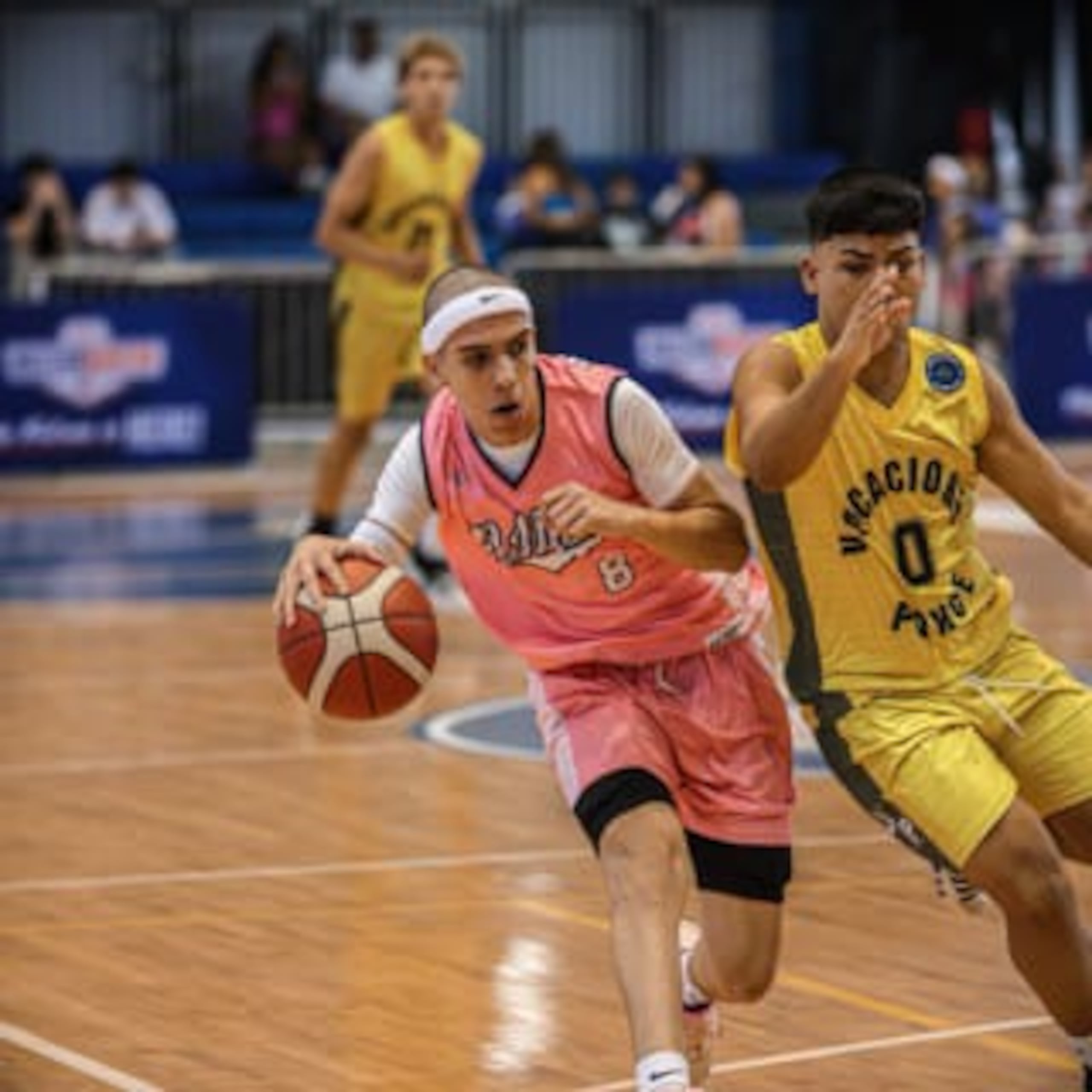 Jonel Vargas, de la Escuela Manuel Méndez Liciaga, protege el balón ante una gestión defensiva de la Escuela Vocacional de Ponce en Gurabo.
