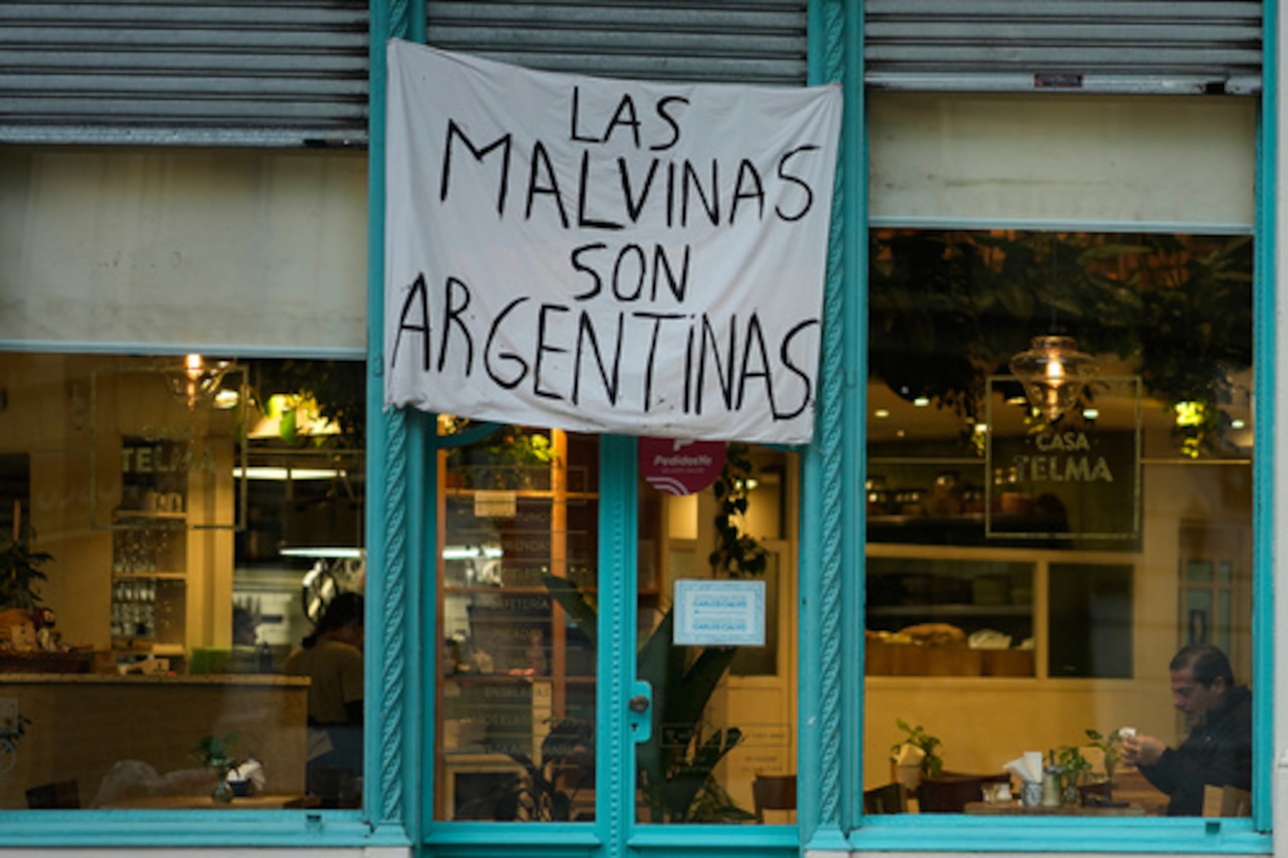 Un hombre está sentado en un restaurante en el que se exhibe una pancarta en la que se lee «Las Malvinas son argentinas», en referencia a las Islas Falkland, también conocidas como Malvinas, en Buenos Aires (Argentina), el lunes 27 de julio de 2026. (Foto AP/Natacha Pisarenko)