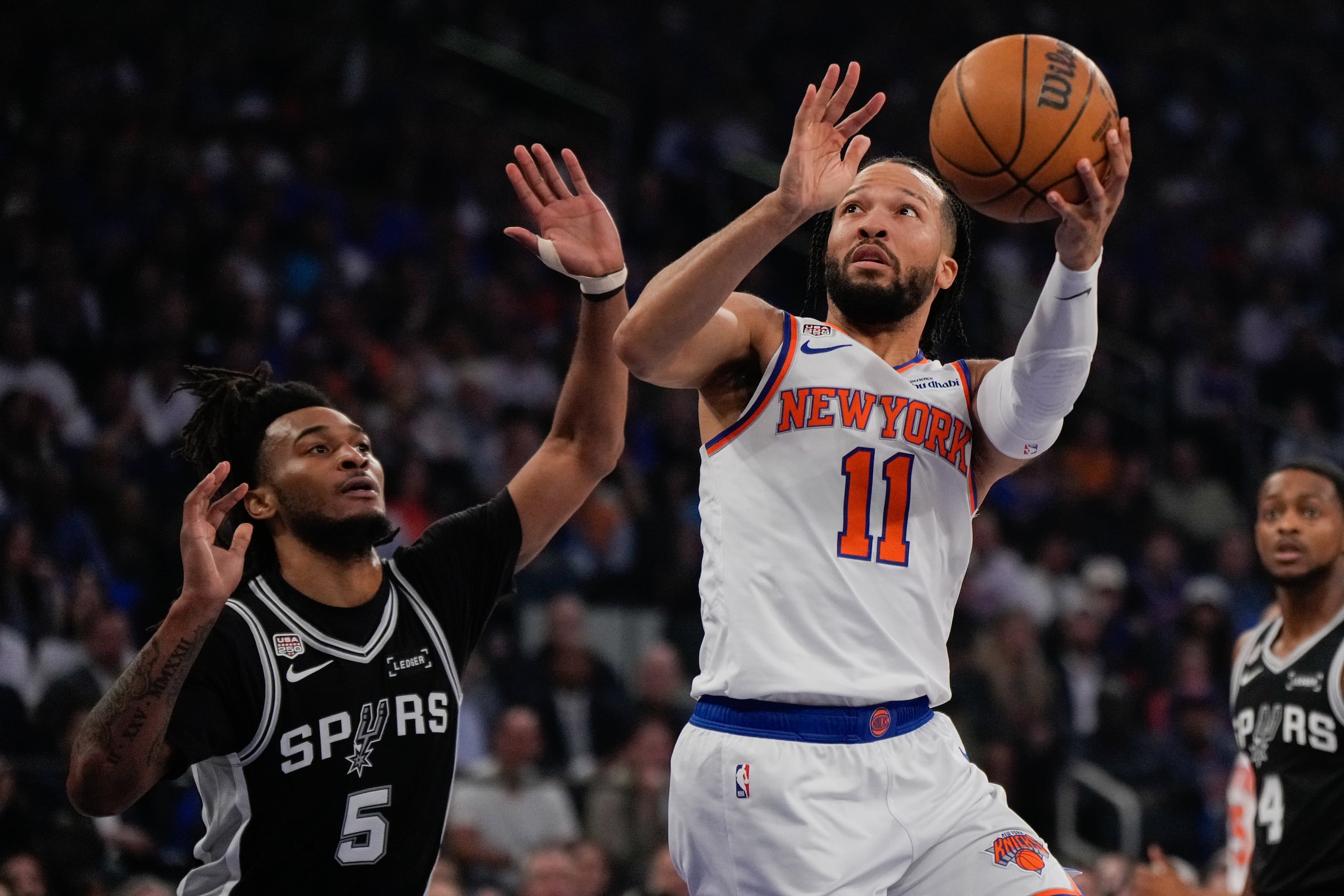 Jalen Brunson, de Nueva York, lanza ante la defensa de Stephon Castle, de los Spurs de San Antonio.