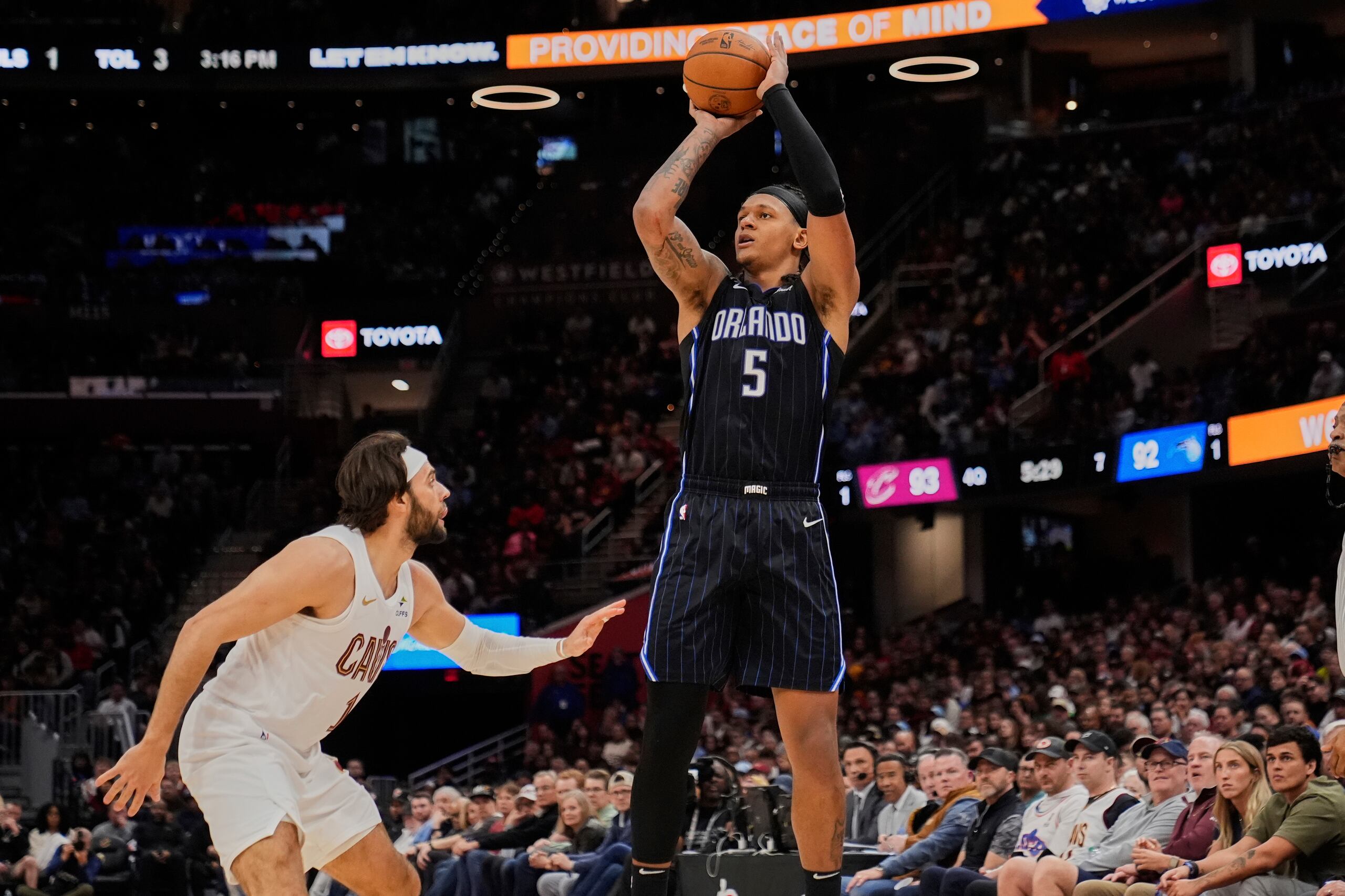 El alero del Magic de Orlando Paolo Banchero (5) dispara sobre el escolta de los Cavaliers de Cleveland, Max Strus, a la izquierda, en la segunda mitad el domingo 16 de marzo de 2025, en Cleveland.