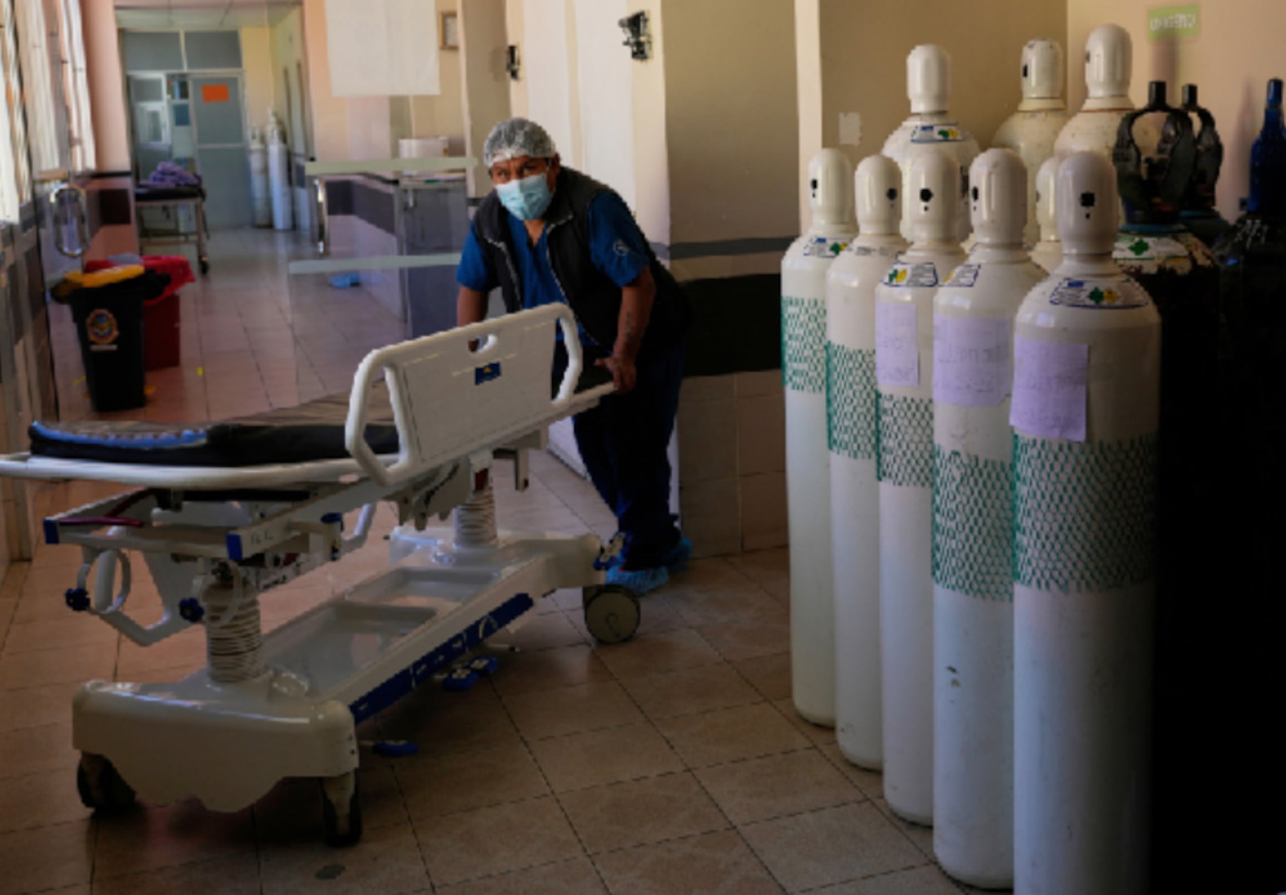 Un trabajador sanitario empuja una camilla junto a bombonas de oxígeno en el Hospital General Público, en medio de la escasez de oxígeno provocada por los bloqueos de carreteras, en La Paz, Bolivia, el martes 2 de junio de 2026. (Foto AP/Juan Karita)