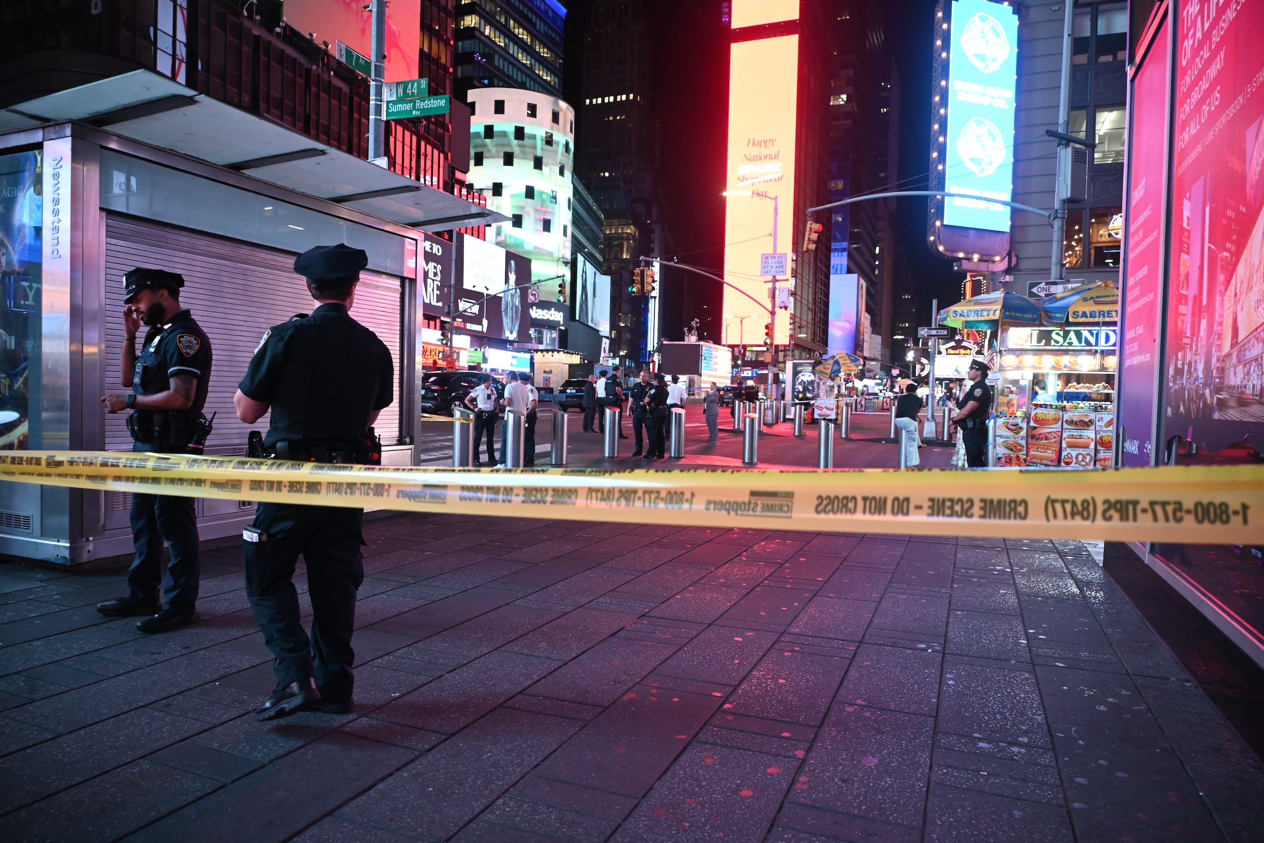 Officers of the New York City Police Department guard the shooting scene with police tape and block off access to pedestrian and vehicular traffic in Times Square. Three people are shot in Times Square, and tourists scatter the area following the gunfire in Manhattan, New York, United States, on August 9, 2025. Three people are struck by gunfire in the area of West 44th Street and 7th Avenue. NYPD officers converge on the area to search for evidence and gather clues. Detectives arrive on the scene, and police implement several road closures in the area. The shooting takes place on Saturday morning at approximately 1:20 AM. An 18-year-old female, a 19-year-old male, and a 65-year-old male are shot, and the victims are transported by EMS to a local area hospital. (Photo by Kyle Mazza/NurPhoto) (Photo by Kyle Mazza / NurPhoto via AFP)