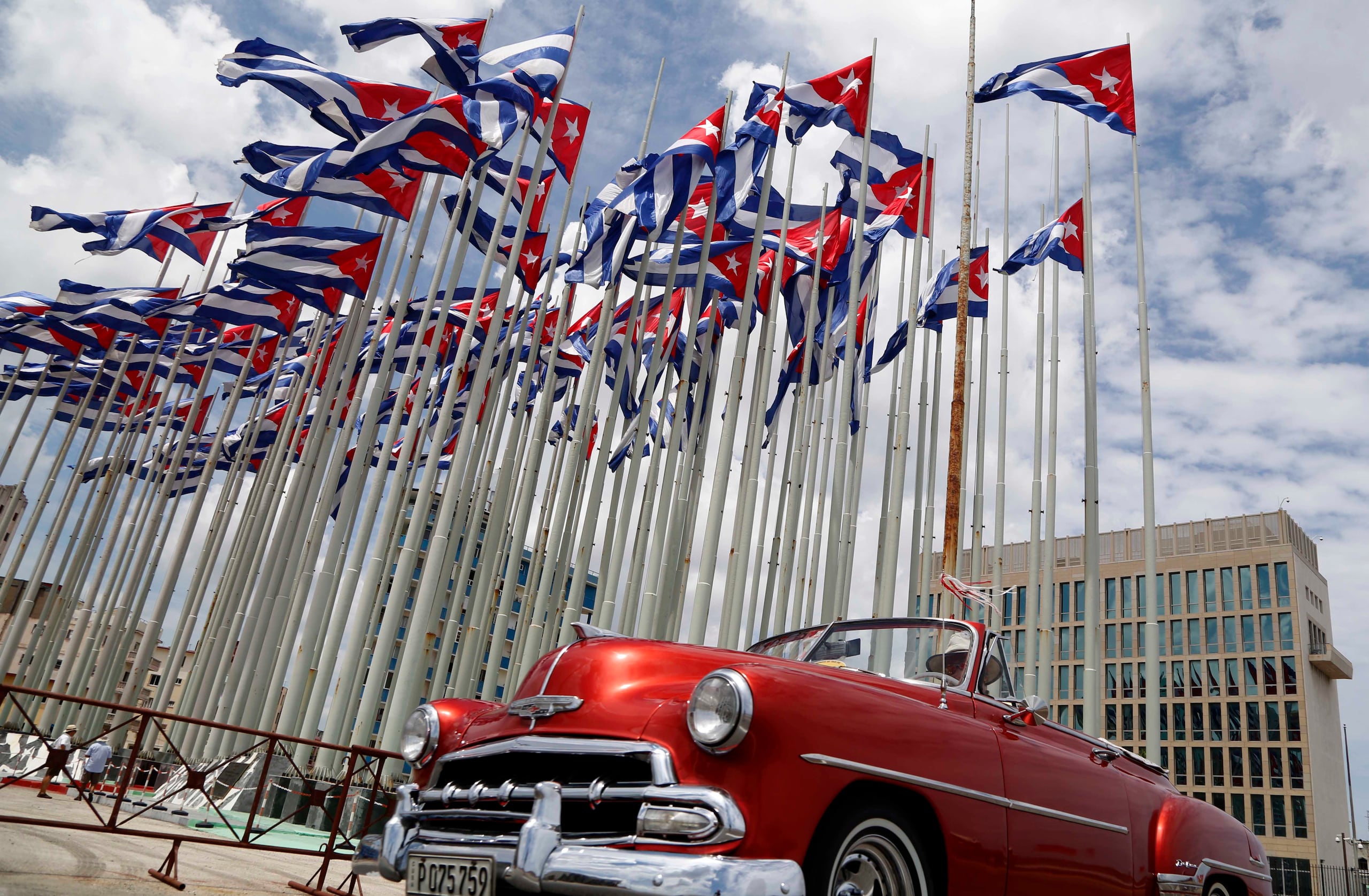 En esta imagen de archivo, un auto descapotable clásico estadounidense pasa junto a la embajada de Estados Unidos mientras las banderas cubanas ondean en la Tribuna Antiimperialista, en el Malecón, en La Habana, Cuba.