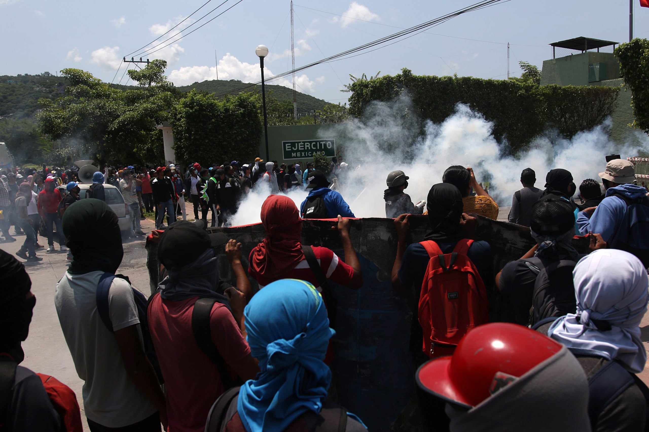 Estudiantes se manifiestan hoy, encapuchados frente a un cuartel militar para exigir justicia por los 43 normalistas desaparecidos de Ayotzinapa, en Iguala, estado de Guerrero (México). EFE/José Luis de la Cruz