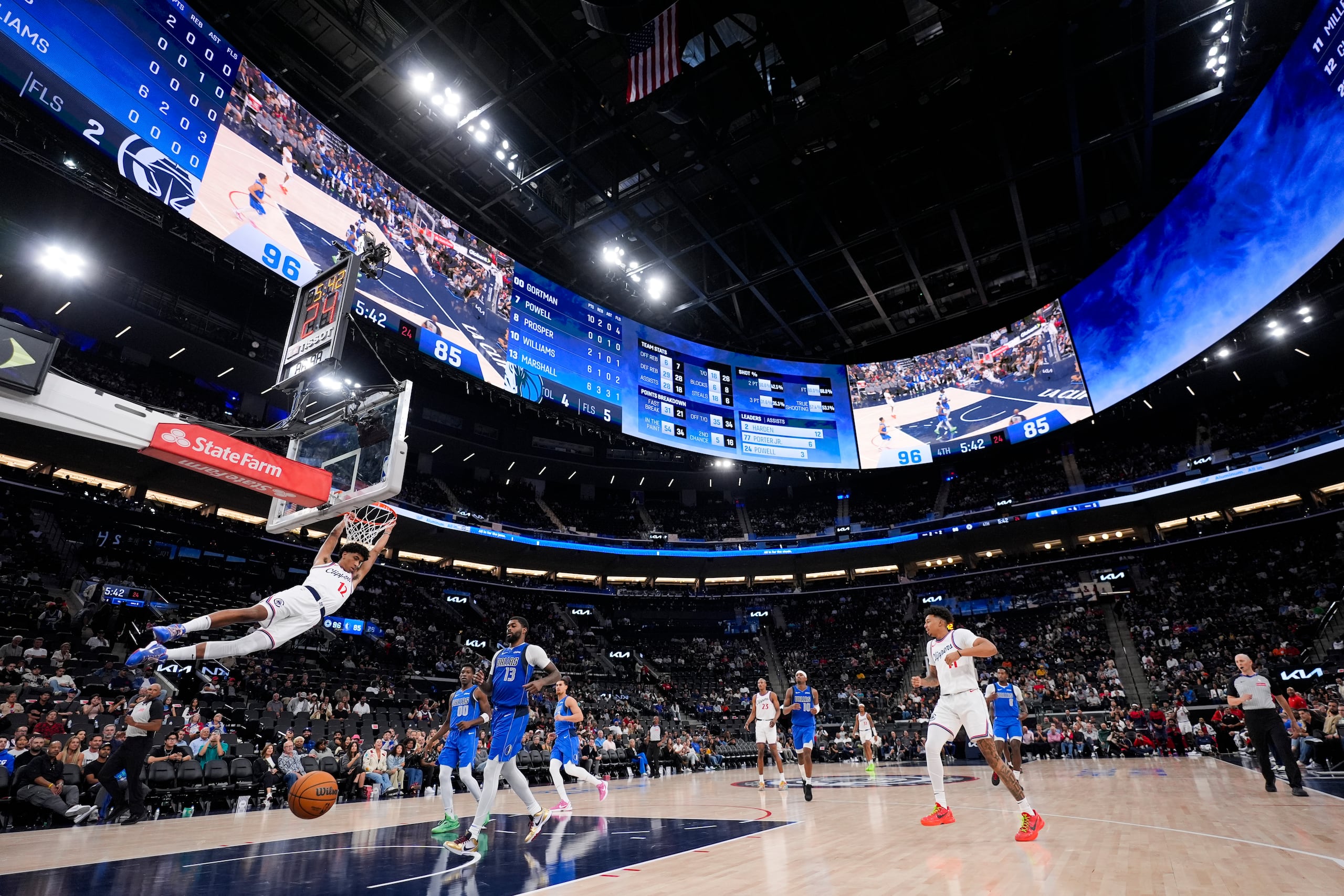 El jugador de los Clippers, Cam Christie (12), donquea un balón ante los Mavericks de Dallas durante la segunda mitad del juego de pretemporada que representó el primer juego de baloncesto en el Intuit Dome.
