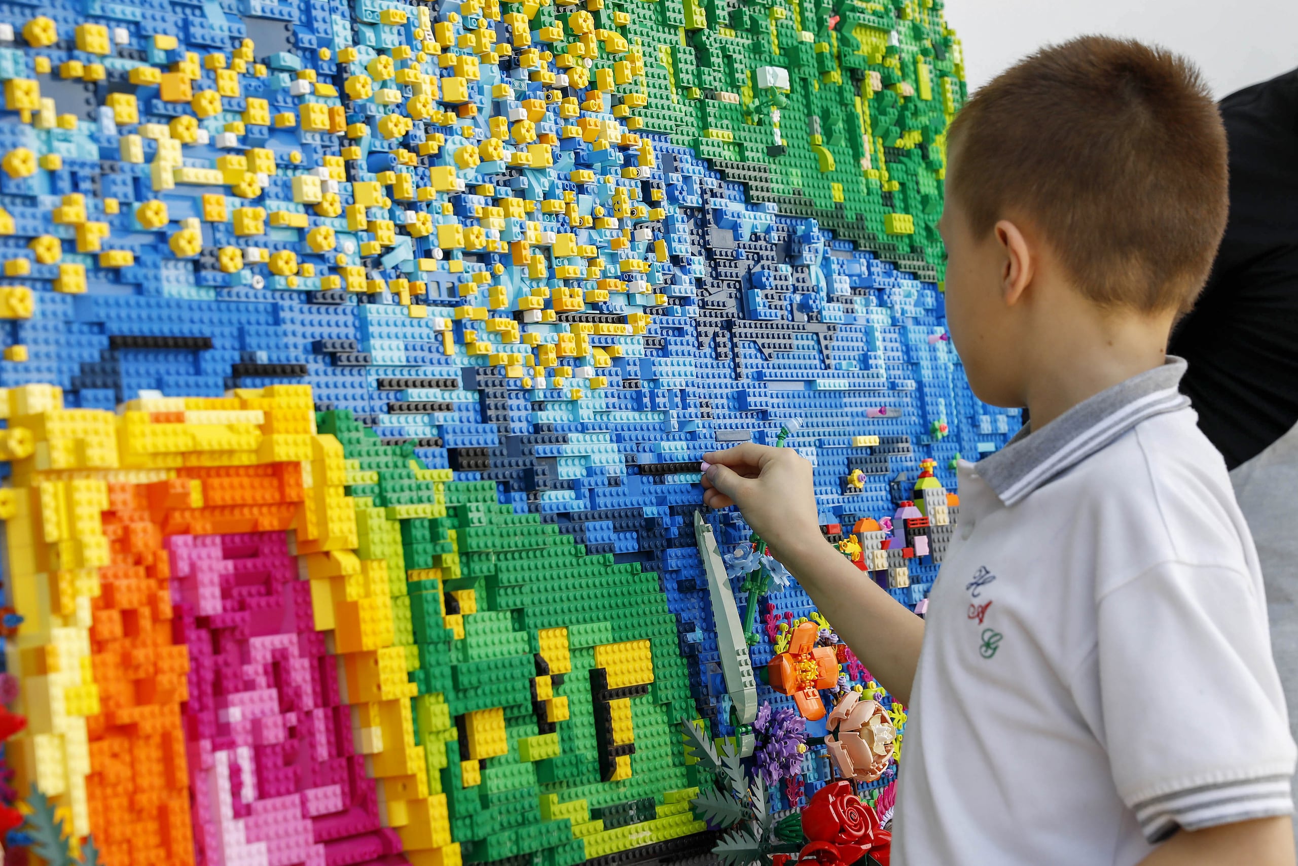 Un niño pone una pieza de Lego en una silleta este 31 de julio de 2024, en el Museo Casa de la Memoria en Medellín (Colombia).