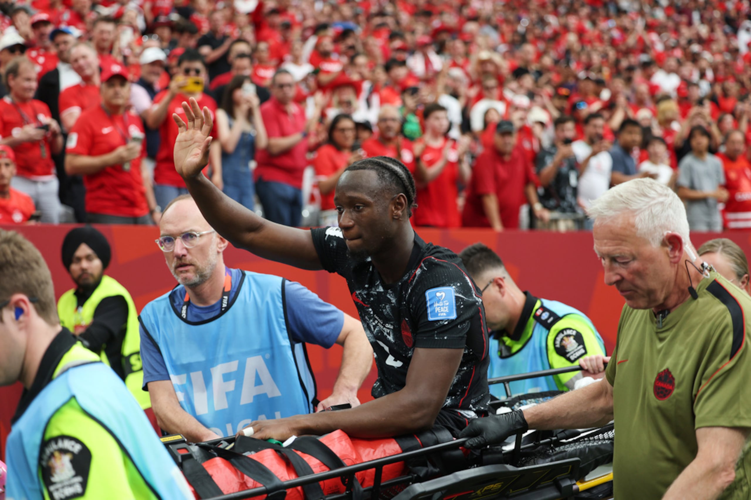 Ismael Kone saluda al público mientras es sacado en camilla del campo durante el juego entre Canadá y Catar en el Mundial.