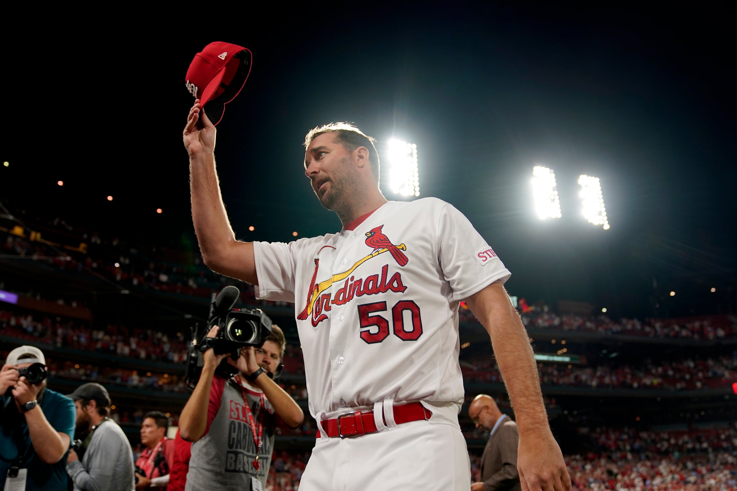 El abridor de los Cardinals de San Luis, Adam Wainwright, se quita la gorra tras recibir una ovación al llegar a 200 victorias en su carrera en el juego ante los Brewers de Milwaukee.