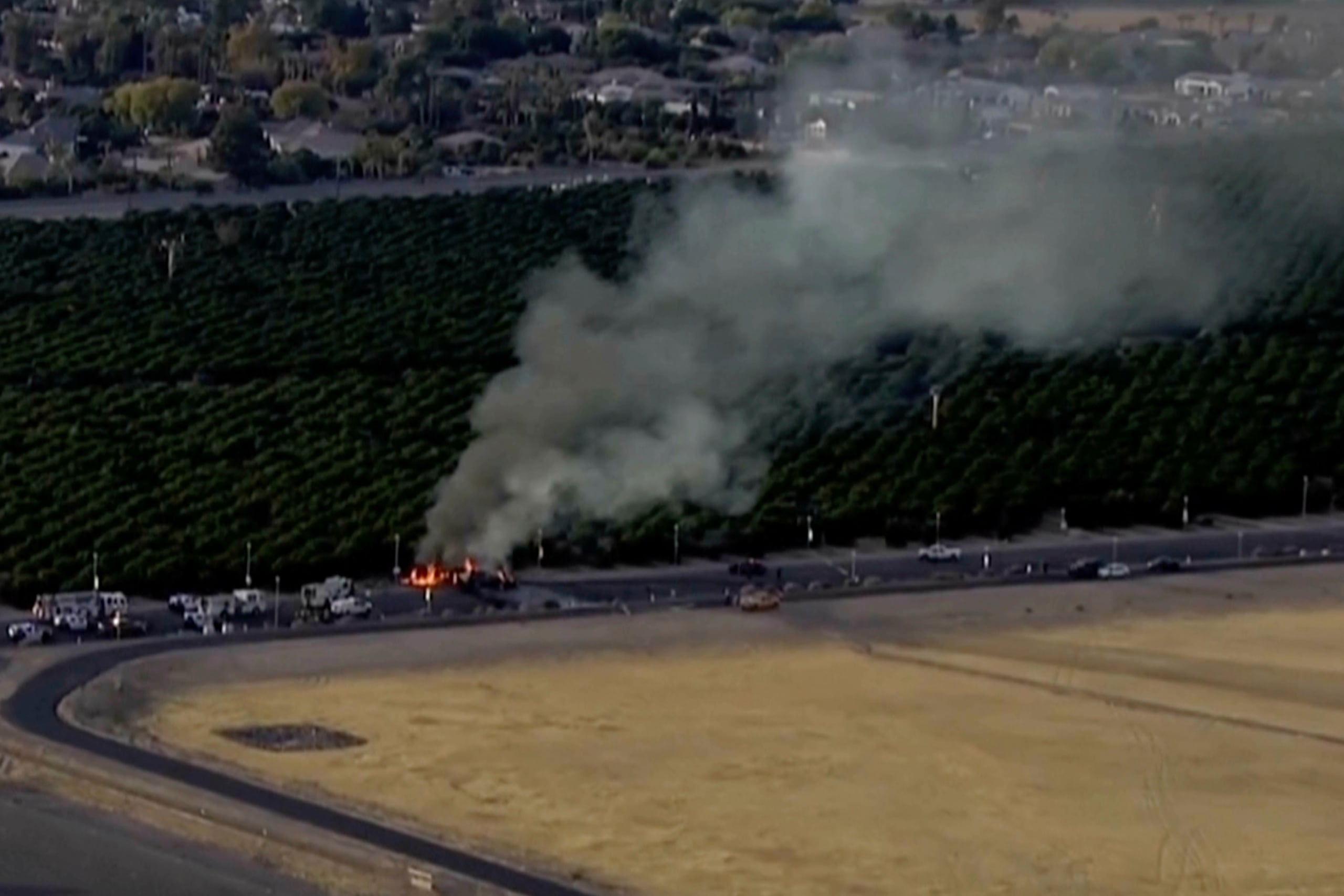 En esta imagen, tomada de un video emitido por KNXV-TV/ABC 15, se muestra una columna de humo en el lugar donde un pequeño avión impactó contra un vehículo, el 5 de noviembre de 2024, en Mesa, Arizona. (KNXV-TV/ABC 15 Arizona via AP)