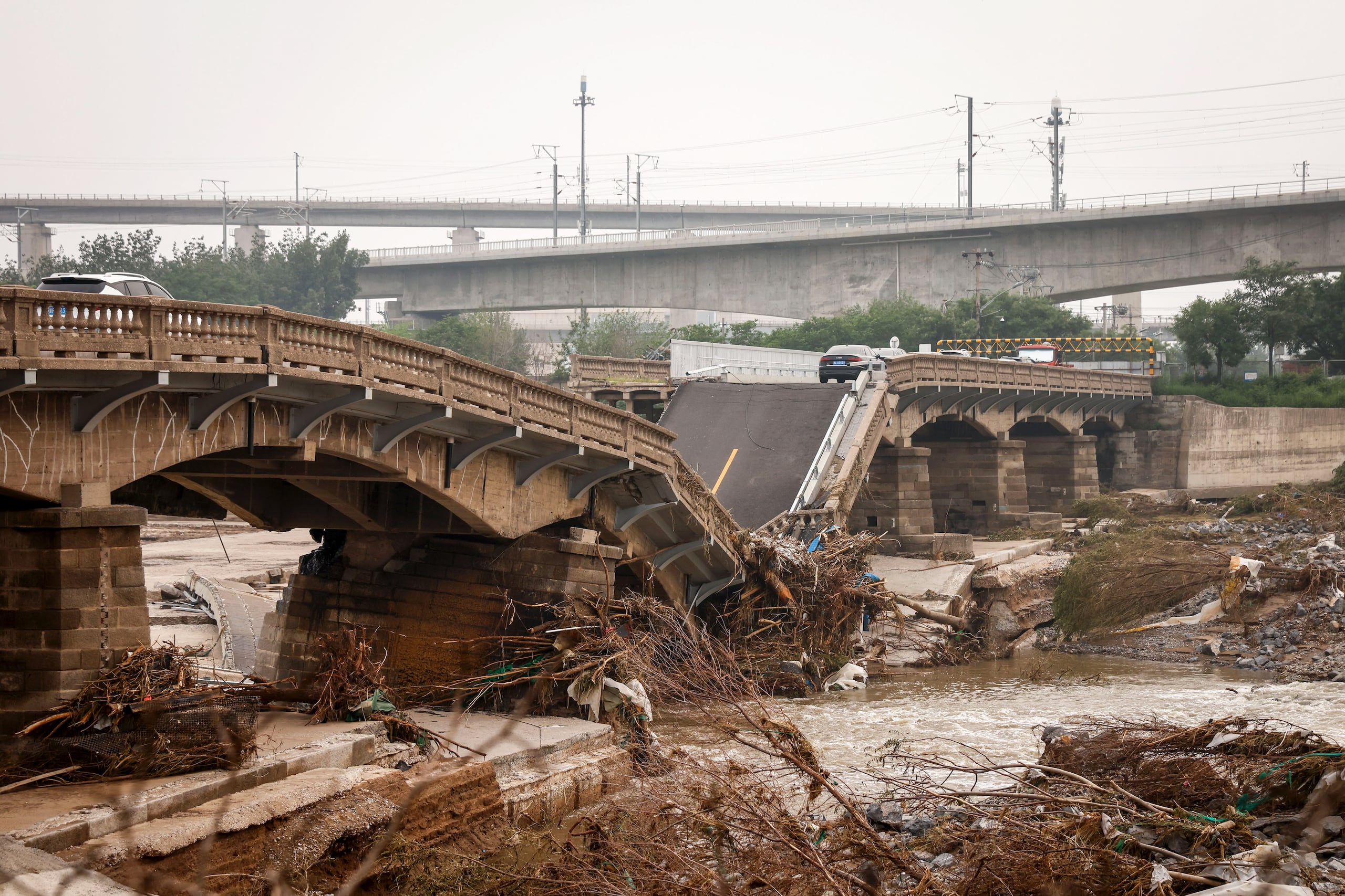 El drástico declive de la expansión económica, la mala calidad de la infraestructura, la escasa supervisión de seguridad y el deseo de las empresas de reducir costos para ahorrar, han causado una serie constante de accidentes letales en sus obras. En la imagen de archivo, un puente dañado tras fuertes lluvias e inundaciones en el distrito de Fengtai, al oeste de Beijing, China.