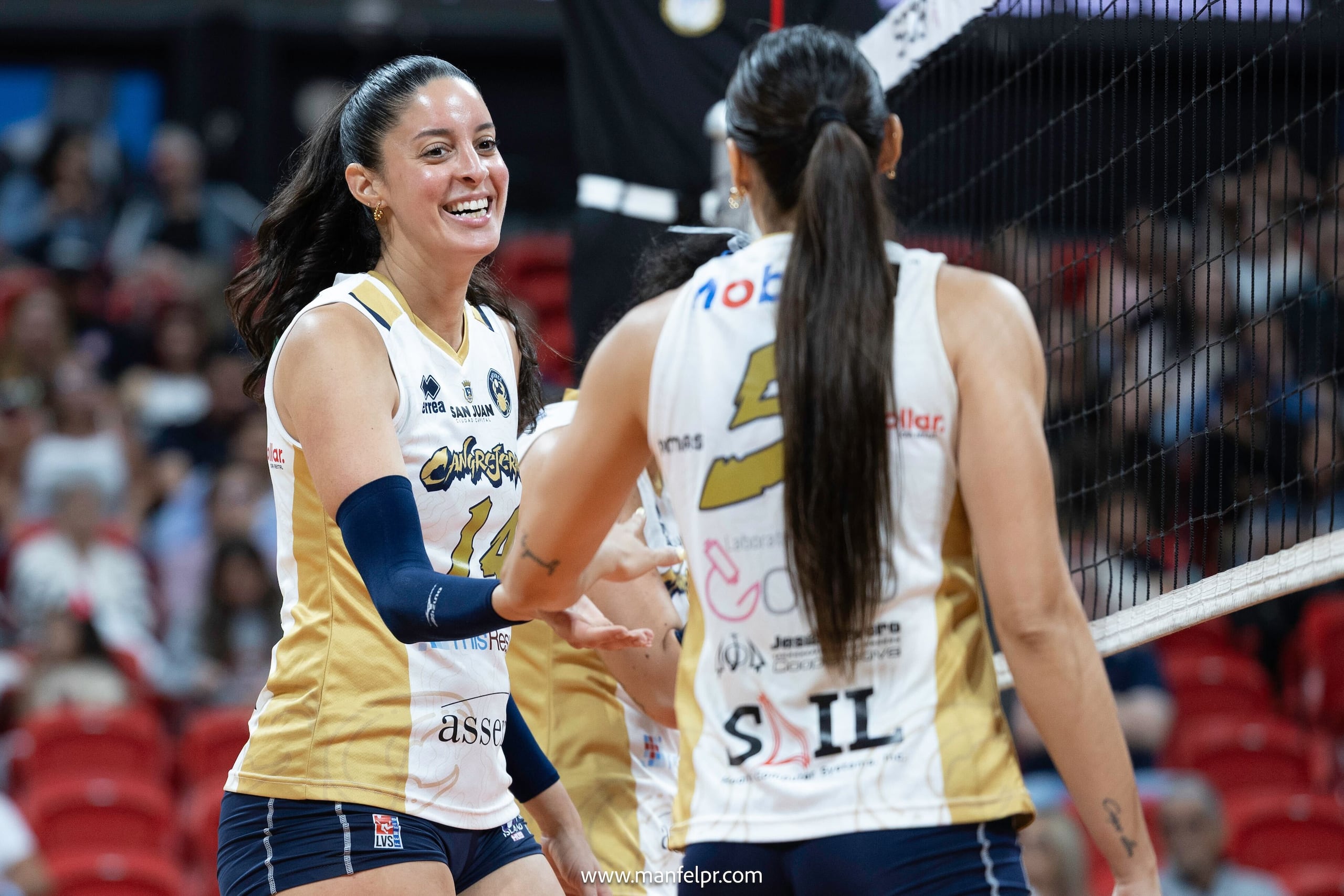 Neira Ortiz y Andrea Rangel celebran una puntuación en la semifinal de la LVSF entre las Cangrejeras de Santurce y las Atenienses de Manatí.