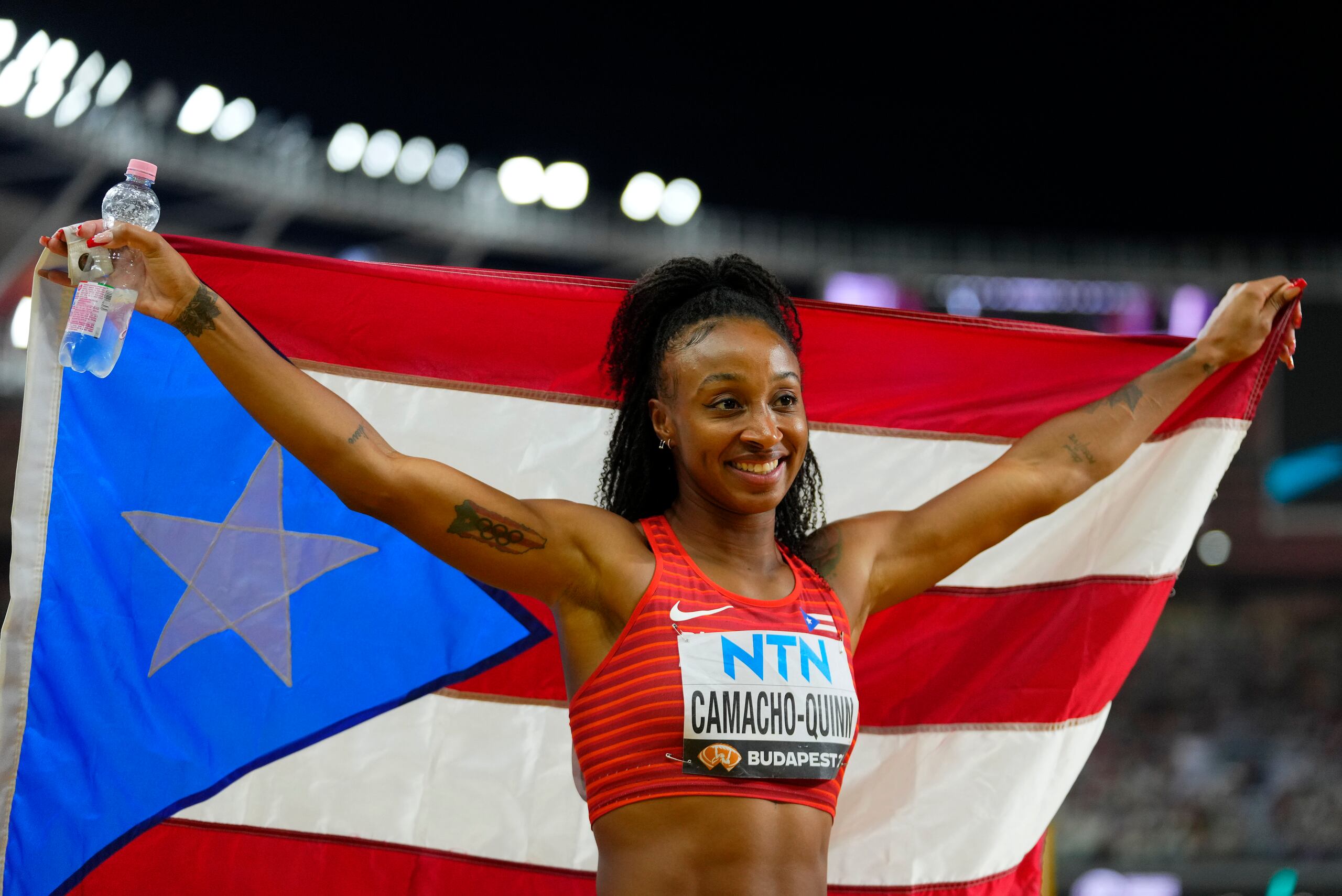 Jasmine Camacho Quinn, aquí con la bandera de Puerto Rico luego de una carrera, es una obvia candidata para abanderada boricua en los Juegos Olímpicos.