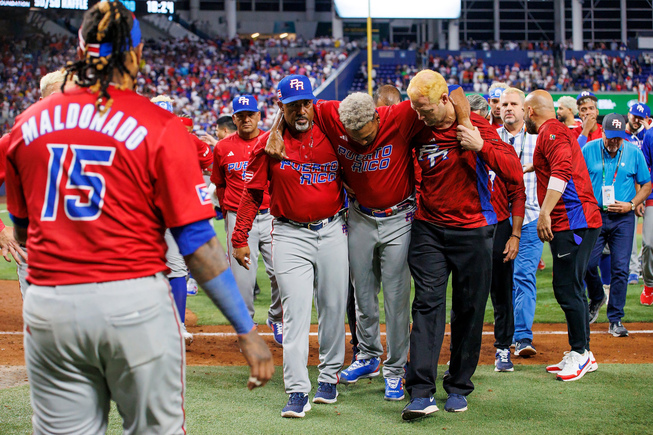 El pitcher puertorriqueño Edwin Díaz (39) recibe auxilio del coach Ricky Bones y el personal médico tras lesionarse en un juego contra la República Dominicana, el miércoles 15 de marzo de 2023, en Miami. (David Santiago/Miami Herald vía AP)