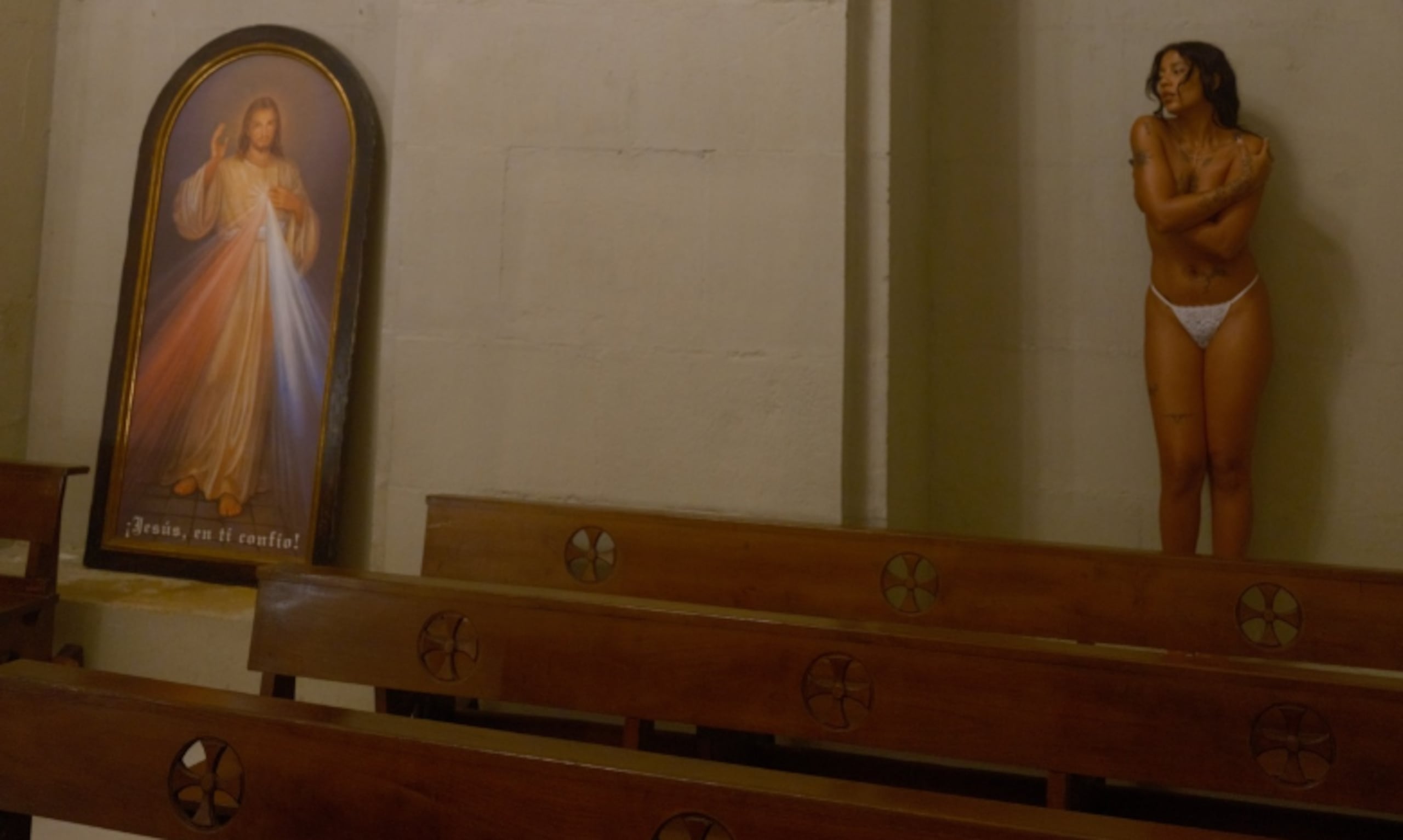 La rapera Tokischa posa cerca de un cuadro de Jesús en una foto que publicó en Instagram.