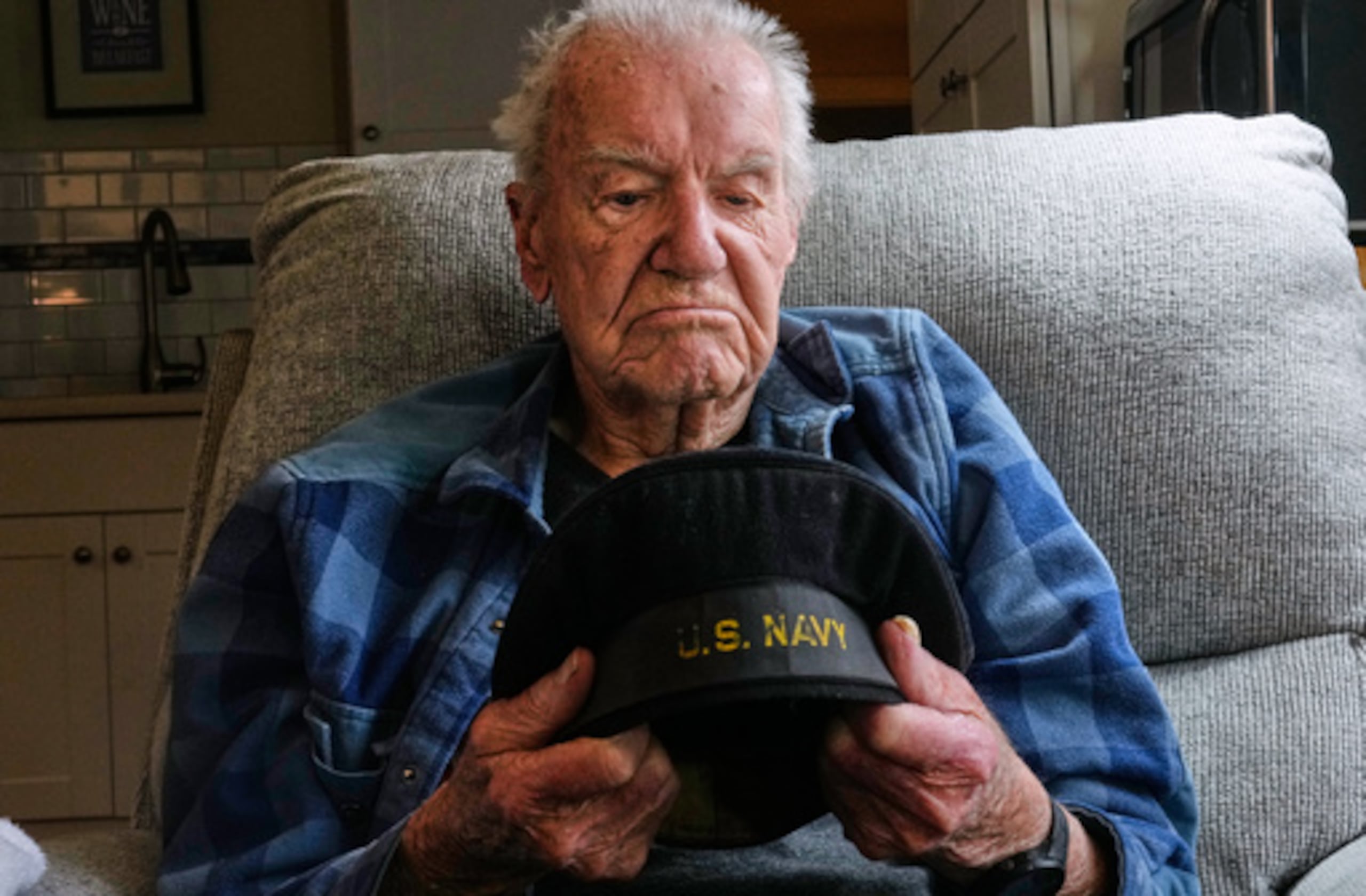 Freeman K. Johnson, un superviviente de Pearl Harbor de 106 años, mira su gorra plana durante una entrevista en su casa, el 6 de mayo de 2026, en Centerville, Massachusetts (AP Photo/Charles Krupa).