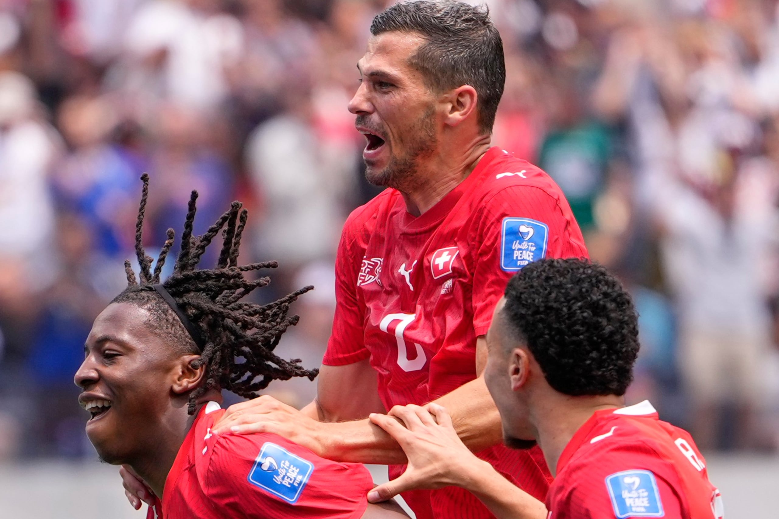 Johan Manzambi, de Suiza, festeja con sus compañeros luego de anotar ante Bosnia y Herzegovina.