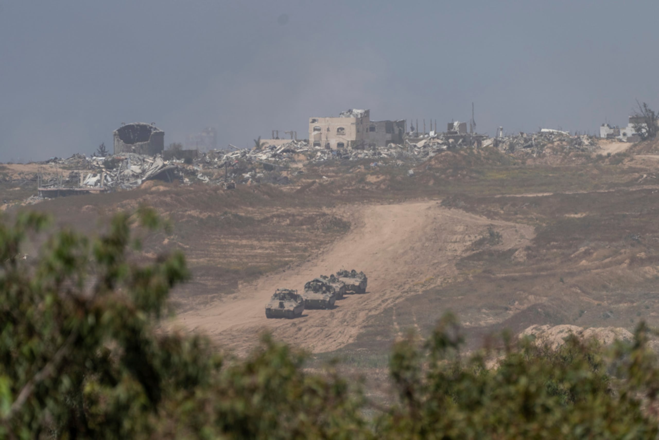 Vehículos blindados de transporte de personal israelíes se mueven cerca de la frontera entre Israel y Gaza, visto desde el sur de Israel, el 17 de abril de 2024.
