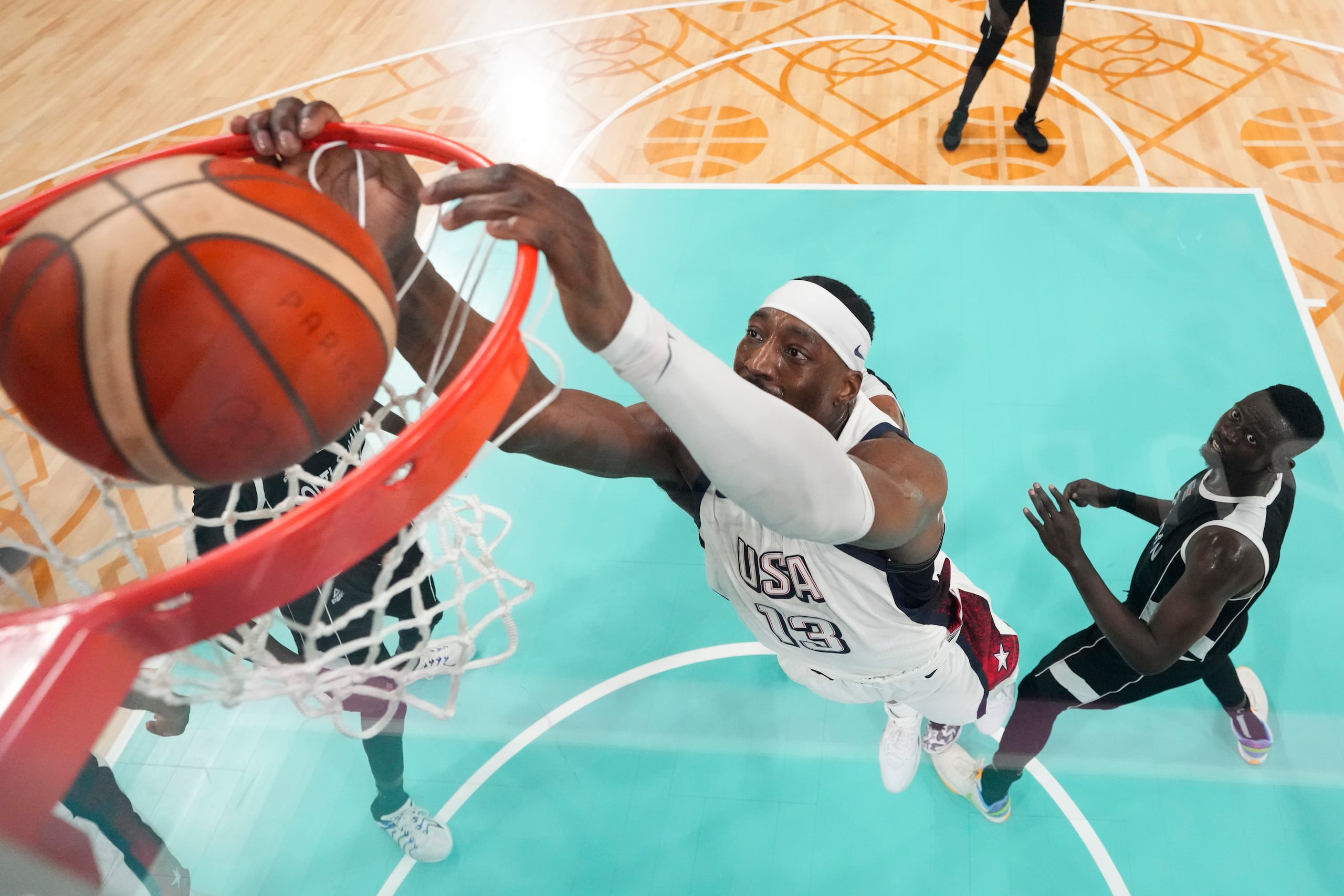 El estadounidense Bam Adebayo completa la volcada ante Peter Jok, jugador de Sudán del Sur, en el baloncesto de los Juegos Olímpicos de París, el miércoles 31 de julio de 2024, en Villeneuve-d'Ascq, Francia. (AP Fhoto/Mark J. Terrill, Pool)