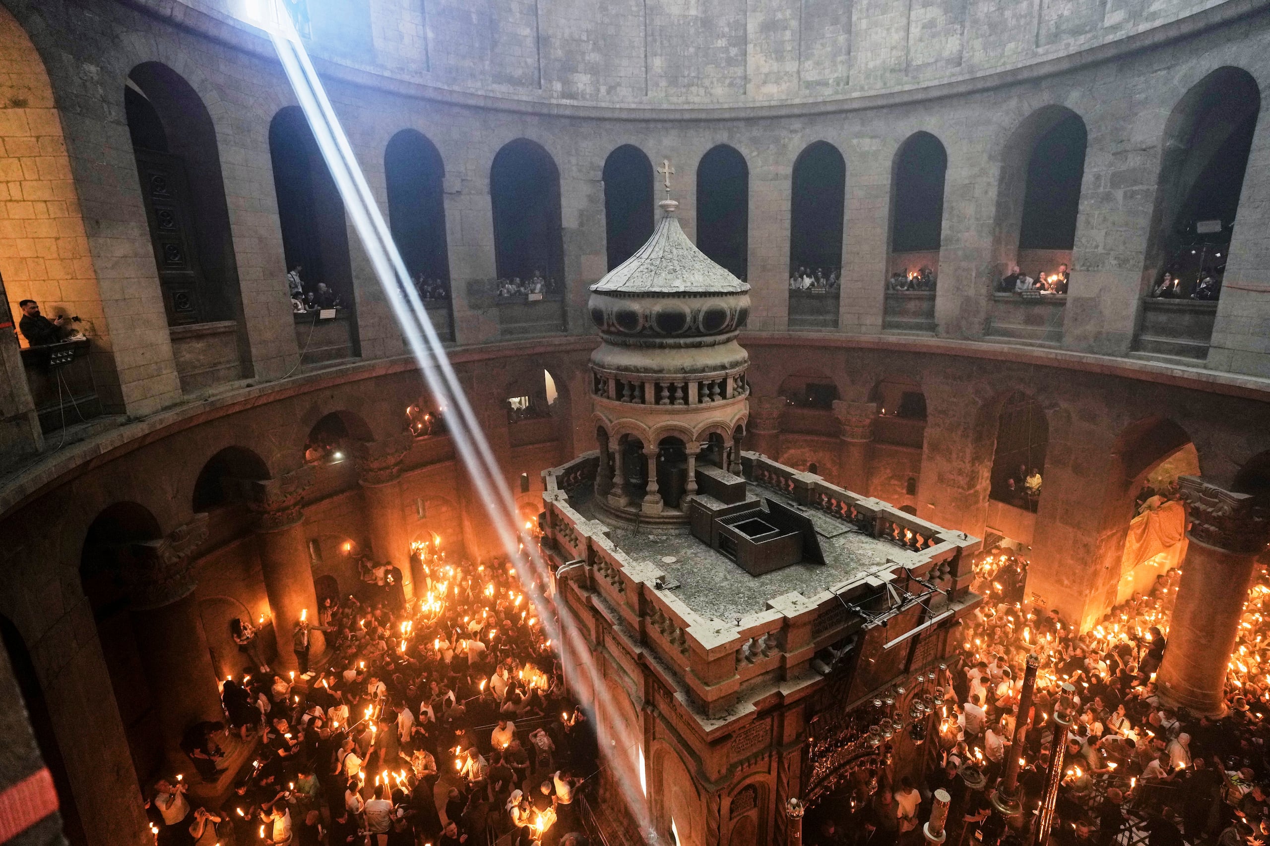 Peregrinos cristianos encienden velas durante la ceremonia del Fuego Sagrado en la Iglesia del Santo Sepulcro, el lugar donde, según la tradición, Jesús fue crucificado y enterrado, en la Ciudad Vieja de Jerusalén. (Foto AP/Mahmoud Illean)