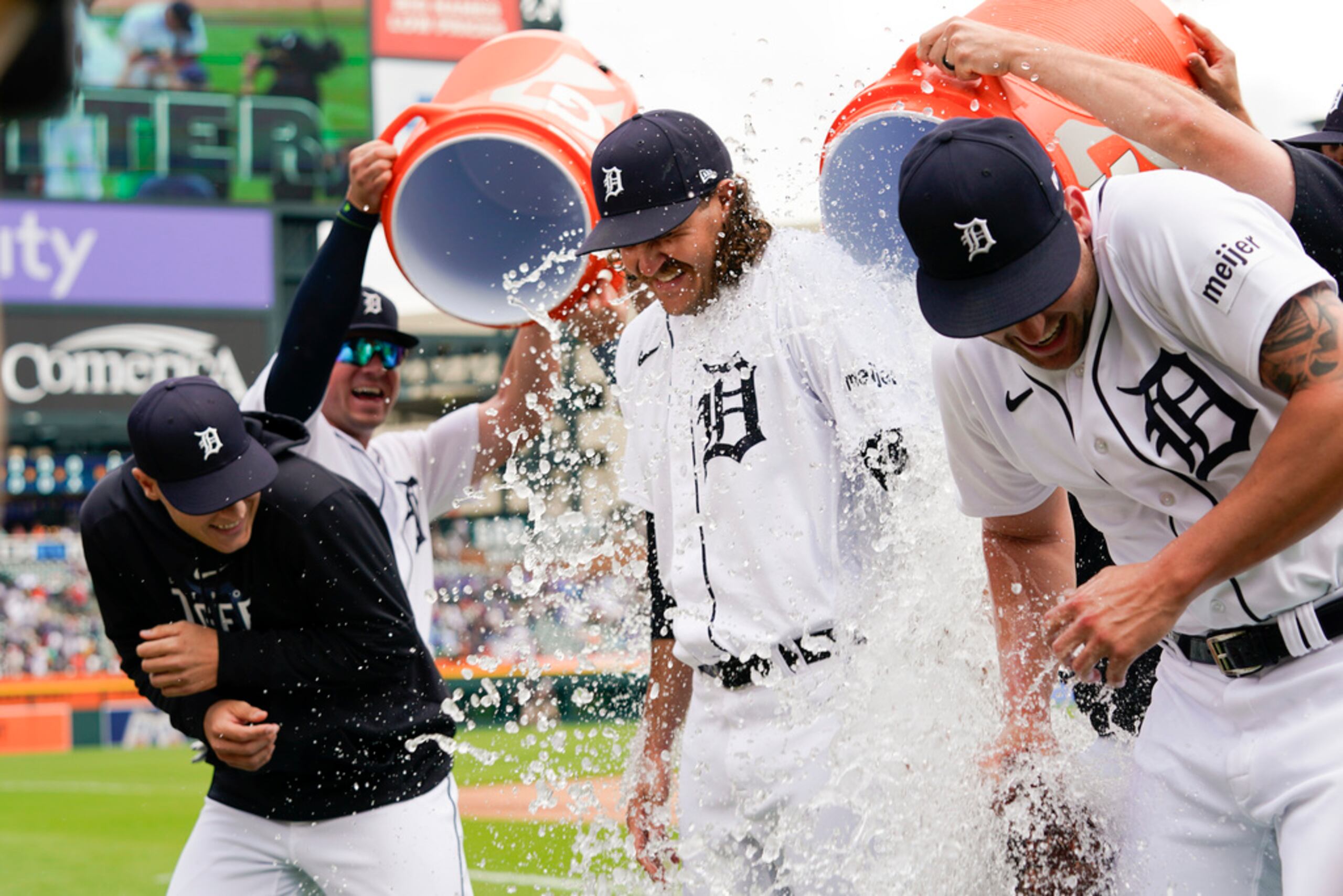 Los lanzadores Matt Manning, Jason Foley y Alex Lange reciben un baño de agua fría al concluir el partido.