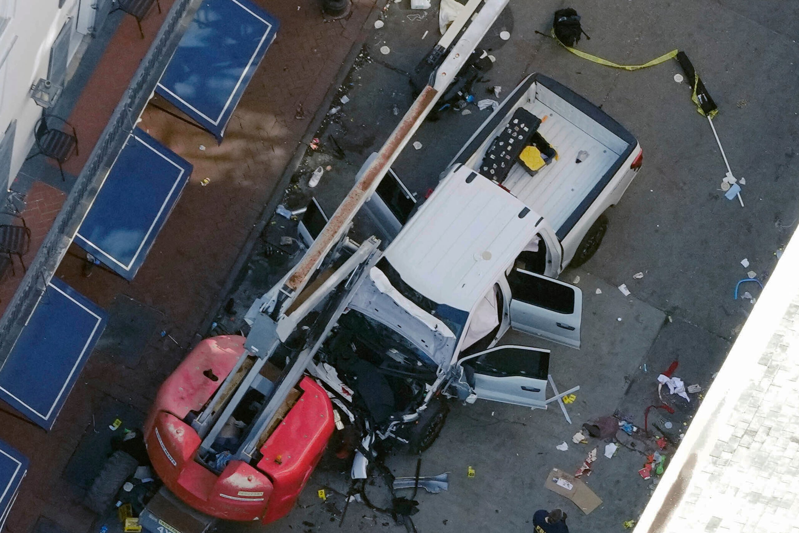 Una bandera negra con letras blancas yace en el suelo enrollada detrás de una camioneta que un hombre arrojó contra una multitud en la calle Bourbon de Nueva Orleans (AP foto/Gerald Herbert)