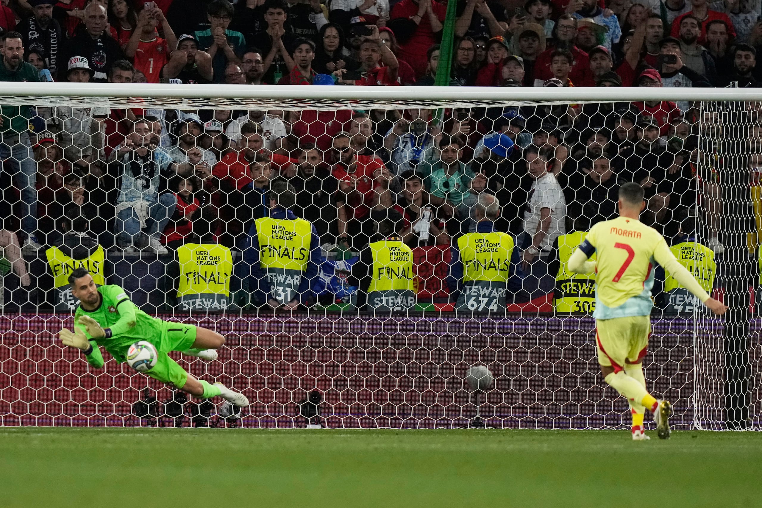 Diogo Costa, izquierda, portero de Portugal, ataja el cobro desde el punto penal del español Álvaro Morata, durante la tanda de desempate de la final de la Liga de Naciones de Europa entre Portugal y España.